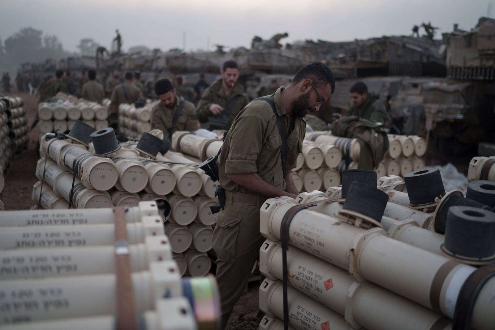 FILE - Israeli soldiers from the artillery unit store tank shells in a staging area at the Israeli-Gaza border in southern Israel, on Jan. 1, 2024. (AP Photo/Leo Correa, File)