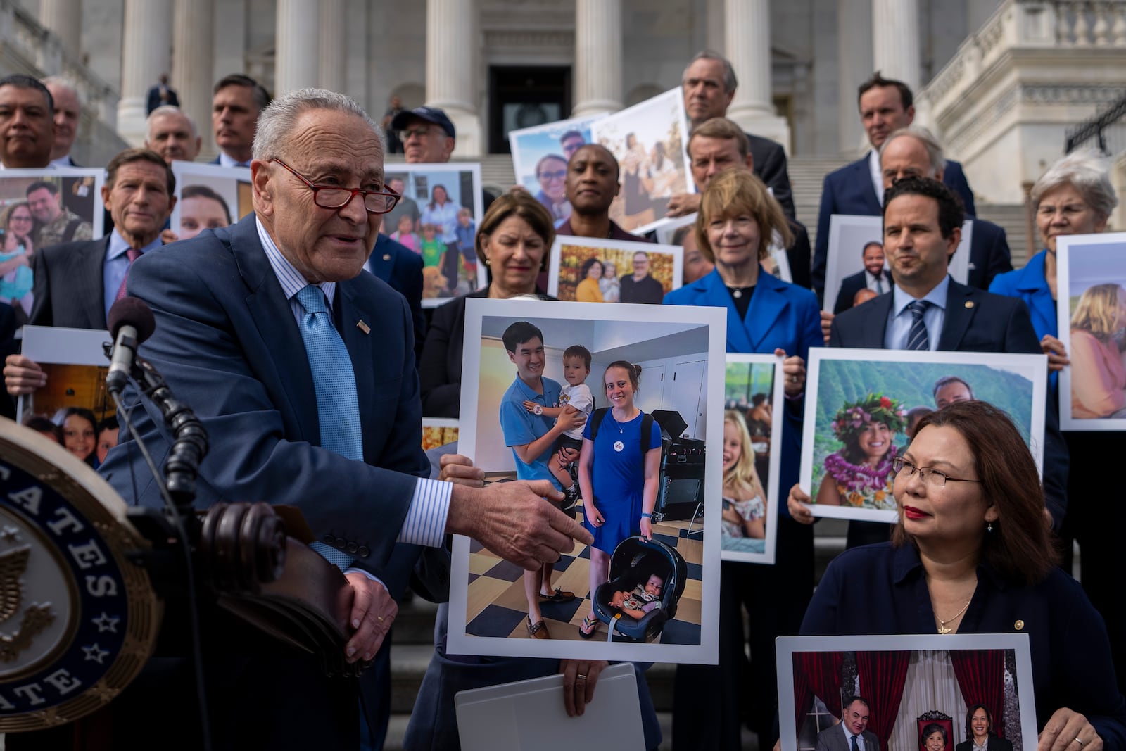 Senate Majority Leader Chuck Schumer, D-NY, left, accompanied by Sen. Tammy Duckworth, D-Ill., right, speaks about the need to protect rights to in vitro fertilization (IVF), on the Senate steps at Capitol Hill in Washington, Tuesday, Sept. 17, 2024. (AP Photo/Ben Curtis)