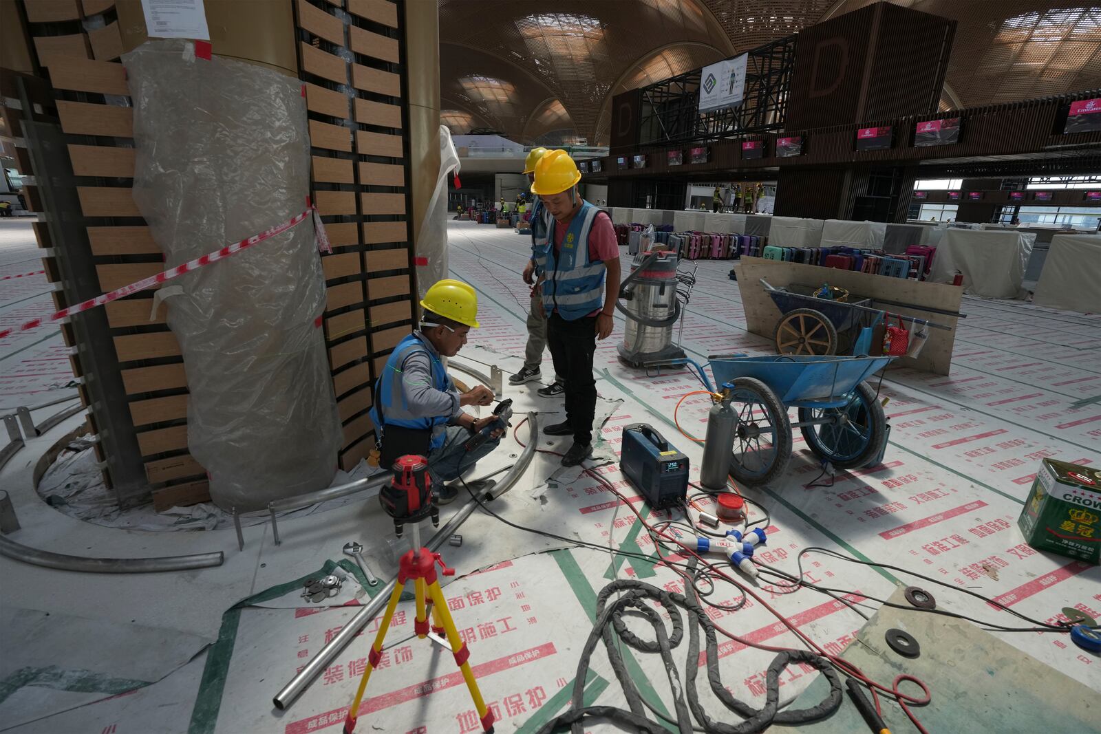 Cambodian workers work inside under a construction of a new airport of Techo International Airport at the outskirts of Phnom Penh Cambodia, Friday, March 21, 2025. (AP Photo/Heng Sinith)