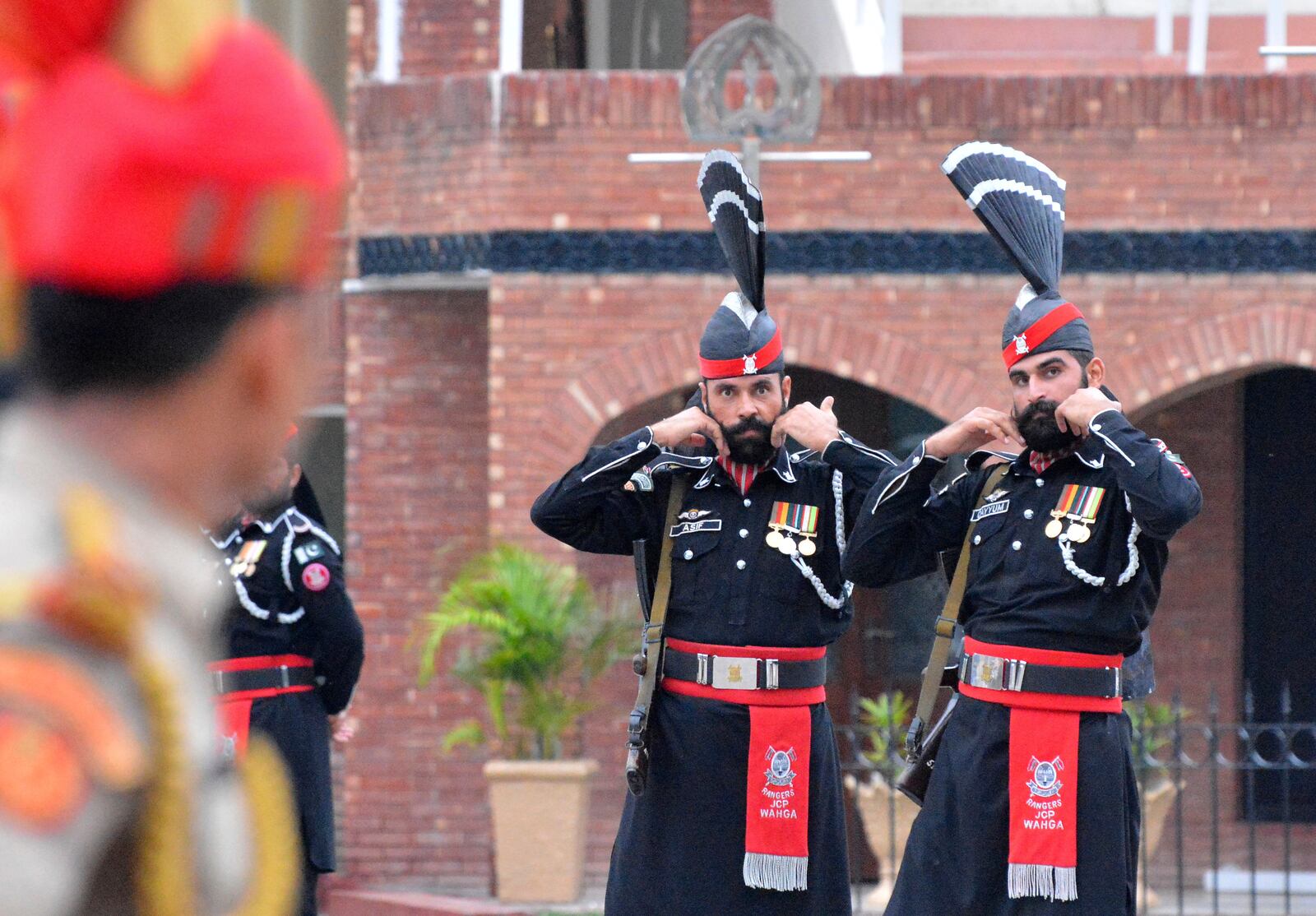 FILE- Pakistan Rangers' soldiers face Indian Border Security Force soldiers at a daily closing ceremony on the Indian side of the Attari-Wagah border, Friday, Aug. 9, 2019. (AP Photo/Prabhjot Gill, File)