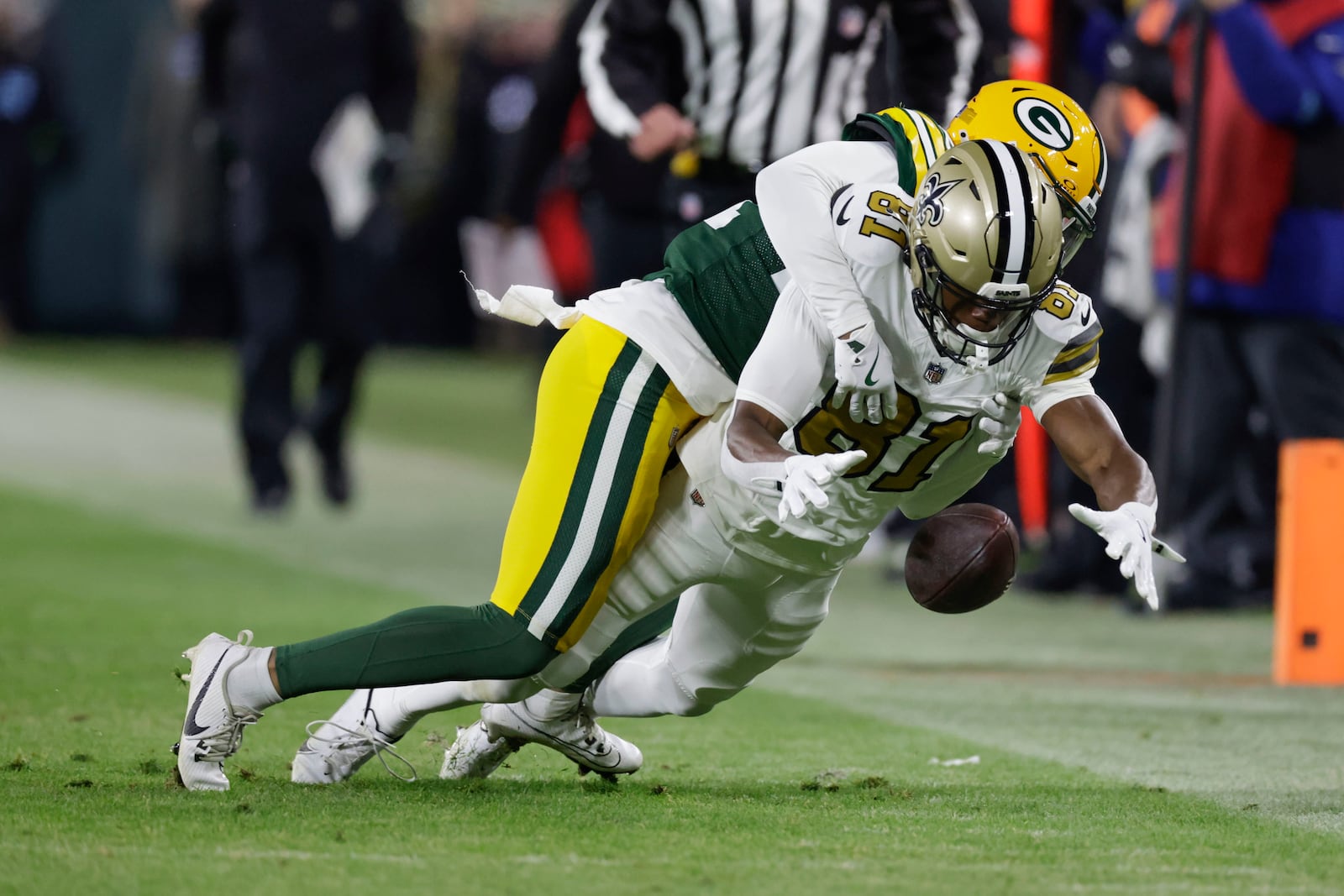 New Orleans Saints wide receiver Kevin Austin Jr. (81) drops the ball as he is hit by Green Bay Packers cornerback Carrington Valentine during the first half of an NFL football game, Monday, Dec. 23, 2024, in Green Bay, Wis. (AP Photo/Matt Ludtke)