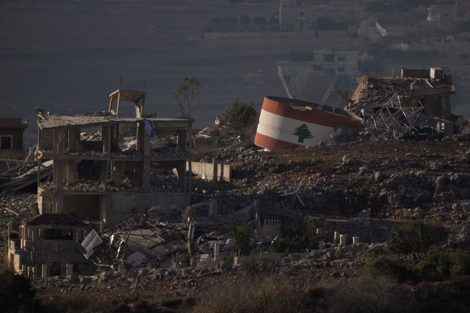 Destroyed buildings stand on an area of a village in southern Lebanon as seen from northern Israel, Monday, Nov. 25, 2024. (AP Photo/Leo Correa)