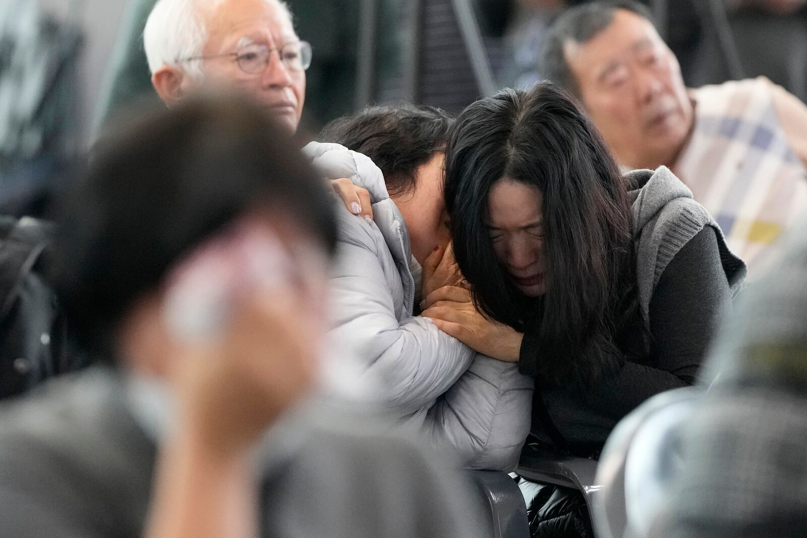 Relatives of the passengers of a plane which burst into flames, react at Muan International Airport in Muan, South Korea, Monday, Dec. 30, 2024. (AP Photo/Ahn Young-joon)