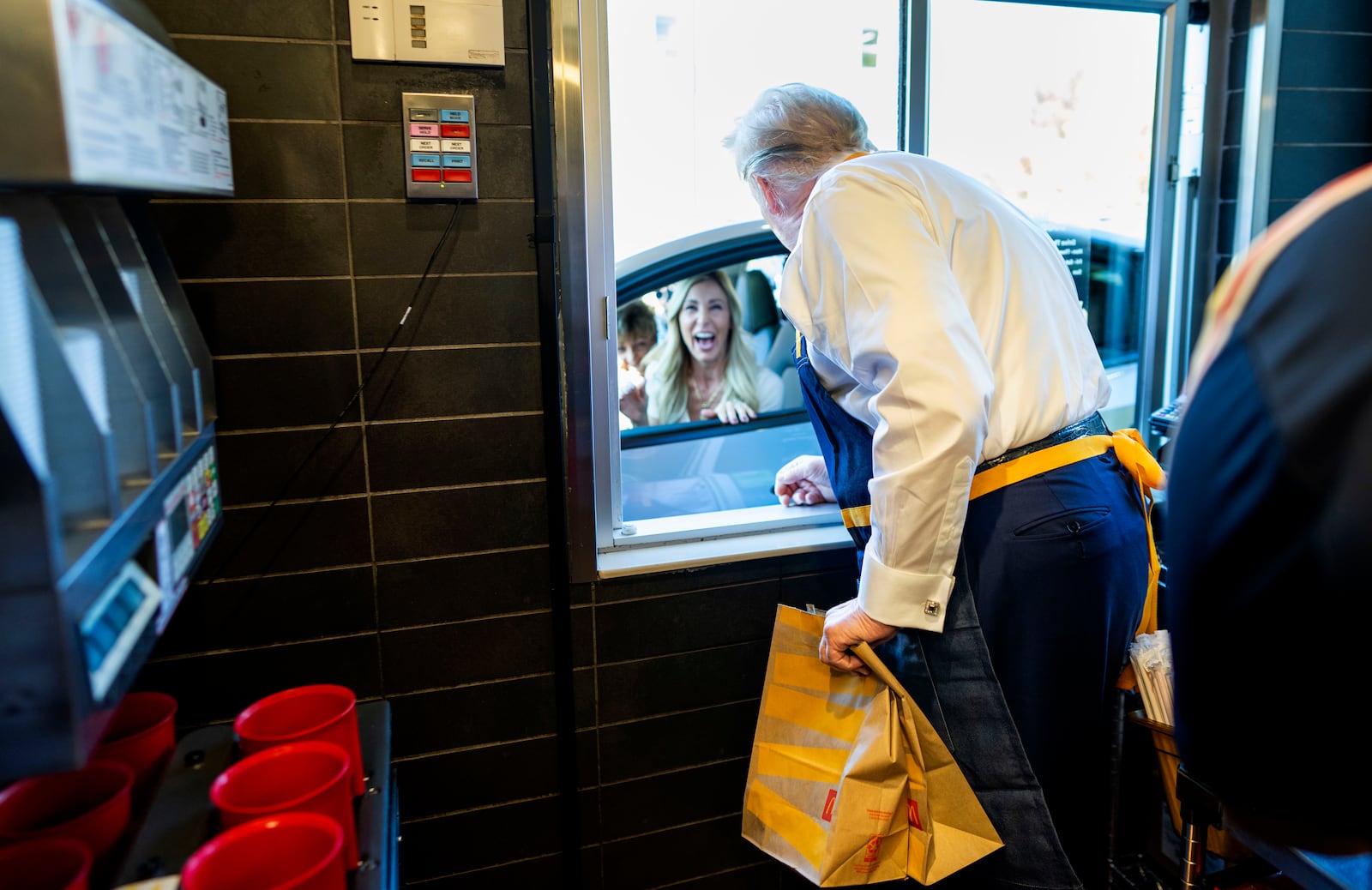 Republican presidential nominee former President Donald Trump hands a customer an order at a drive-thru window during a campaign stop at a McDonald's in Feasterville-Trevose, Pa., Sunday, Oct. 20, 2024. (Doug Mills/The New York Times via AP, Pool)