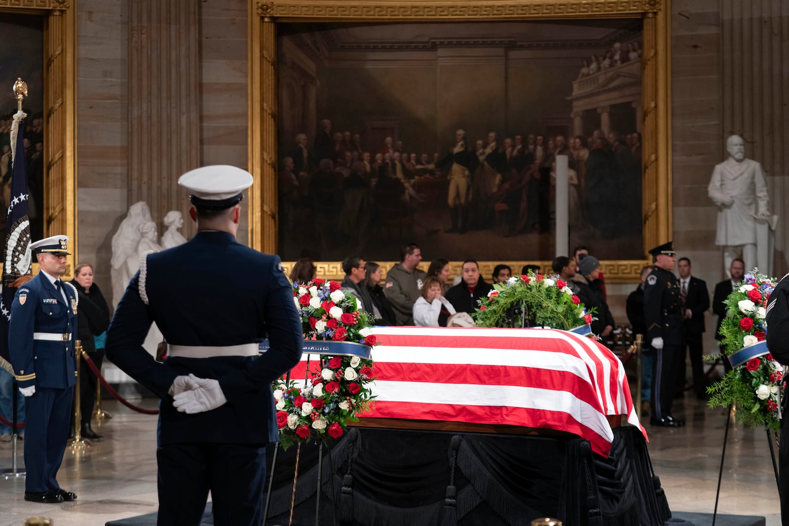 Mourners look at the flag-draped casket of former President Jimmy Carter as he lies in state in the Capitol, Tuesday, Jan. 7, 2025, in Washington. Carter died Dec. 29 at the age of 100. (AP Photo/Jose Luis Magana)