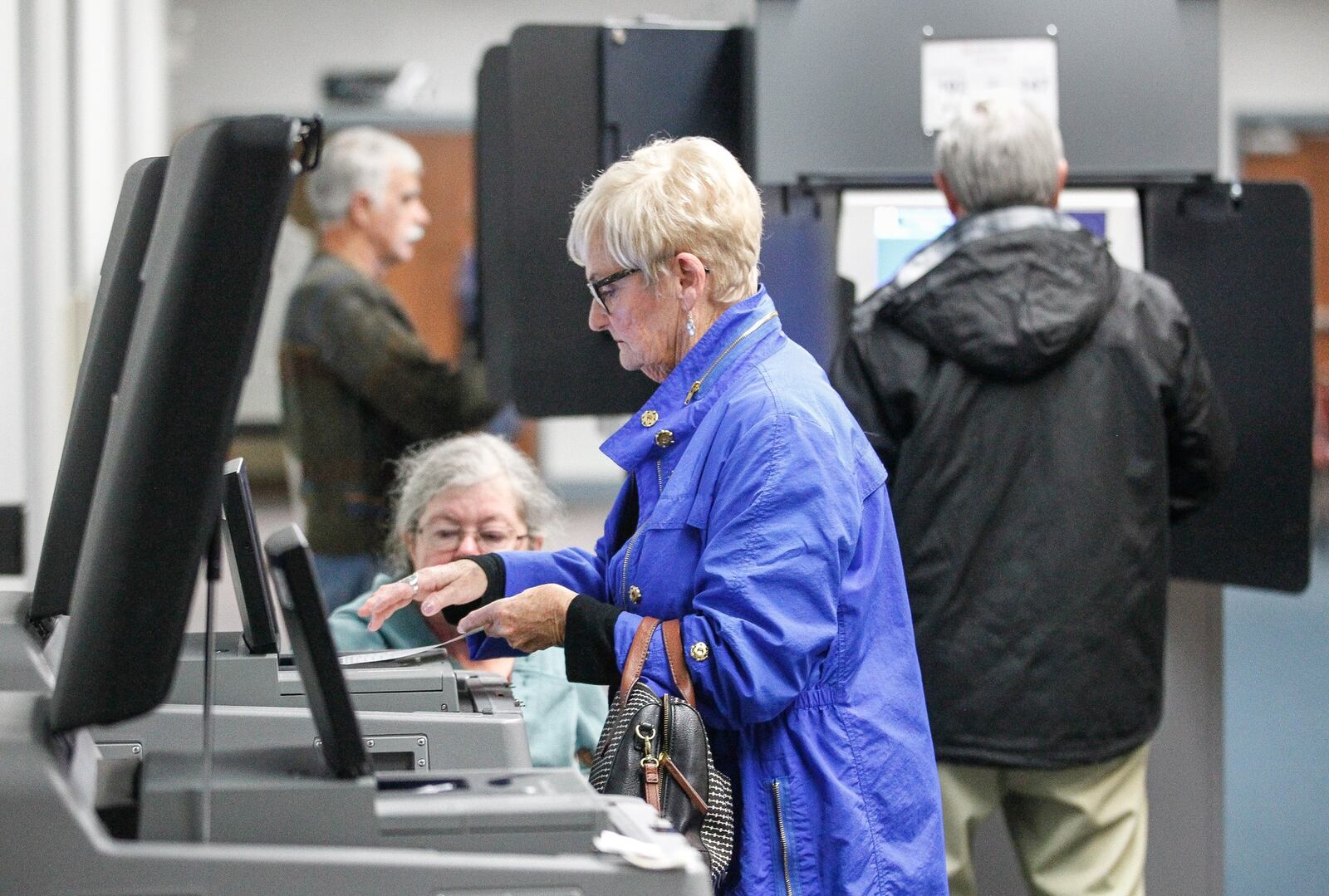 Brenda Netzley of Washington Twp. feeds her paper ballot into a scanner voting at the Washington Twp. Recreation Center for the first time on new equipment purchased by Montgomery County. CHRIS STEWART / STAFF