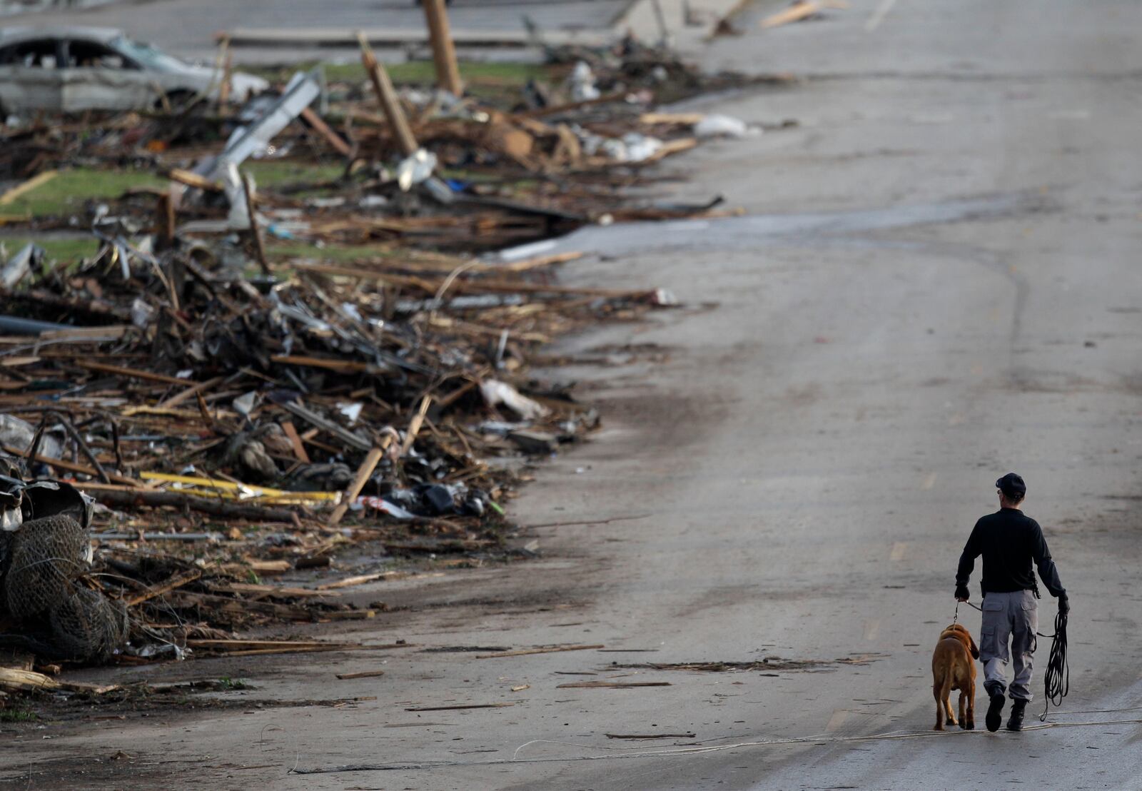 FILE- A rescue worker walks past debris at Joplin High School, which was severely damaged by a tornado in Joplin, Mo., Monday, May 23, 2011. (AP Photo/Charlie Riedel, File)