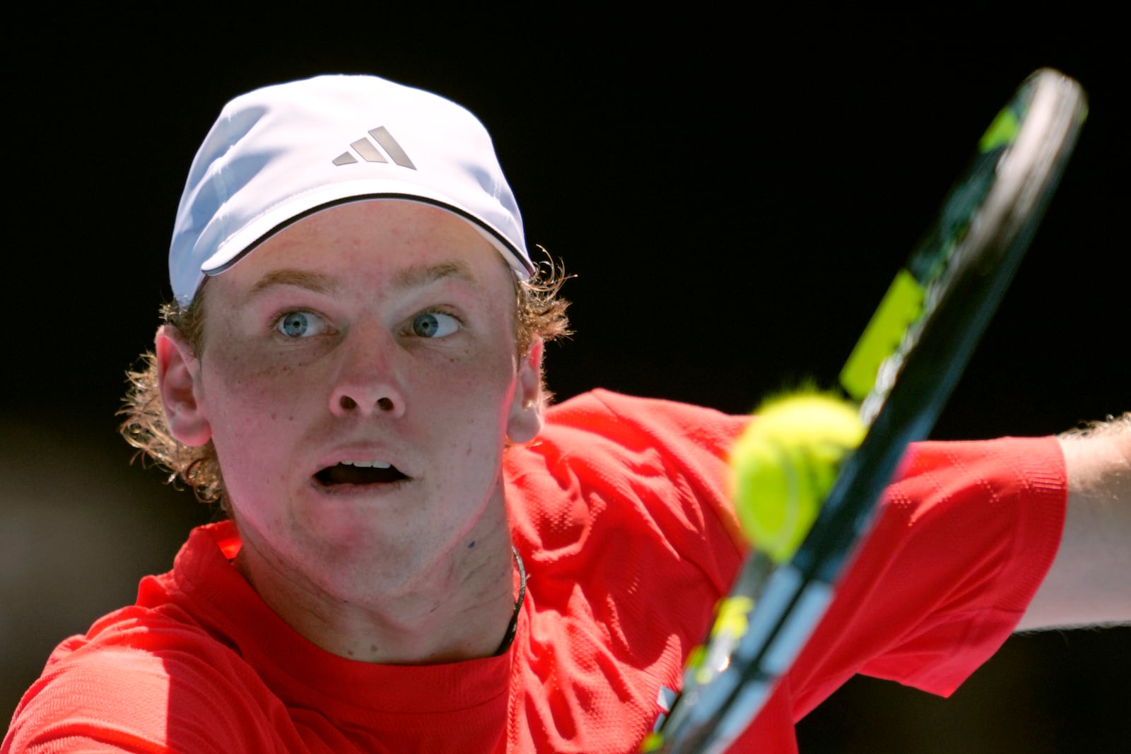 Alex Michelsen of the U.S. plays a backhand return to Stefanos Tsitsipas of Greece during their first round match at the Australian Open tennis championship in Melbourne, Australia, Monday, Jan. 13, 2025. (AP Photo/Ng Han Guan)