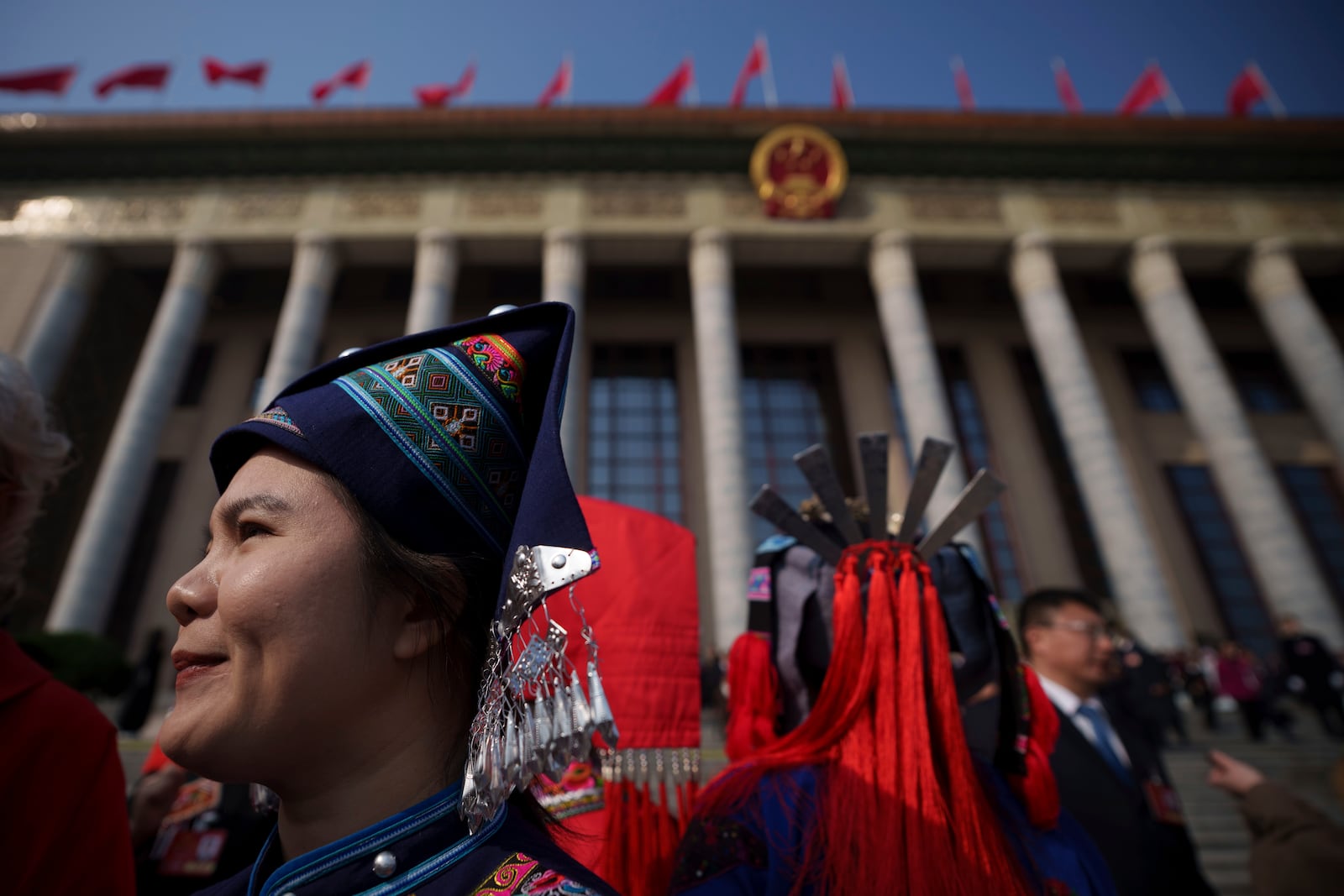 Female ethnic minority delegates leave after the opening session of the National People's Congress (NPC) at the Great Hall of the People in Beijing, China, Wednesday, March 5, 2025. (AP Photo/Vincent Thian)