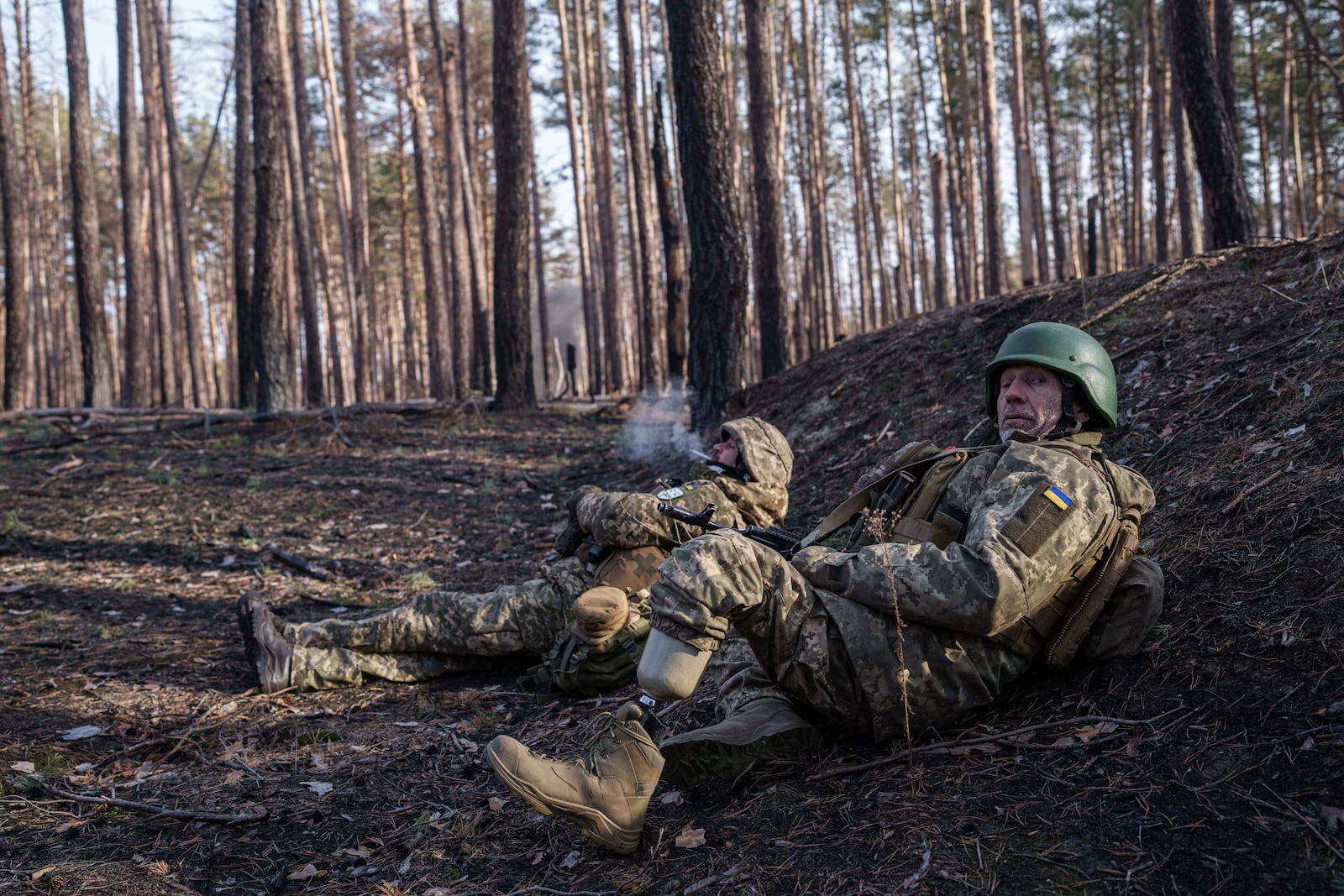 Andrii Serhieiev, foreground, a Ukrainian soldier with the 53rd brigade who lost a leg in battle, works with another soldier to detonate unexploded ordnance near the front line in Ukraine's Donetsk region on Feb. 13, 2025. (AP Photo/Evgeniy Maloletka)