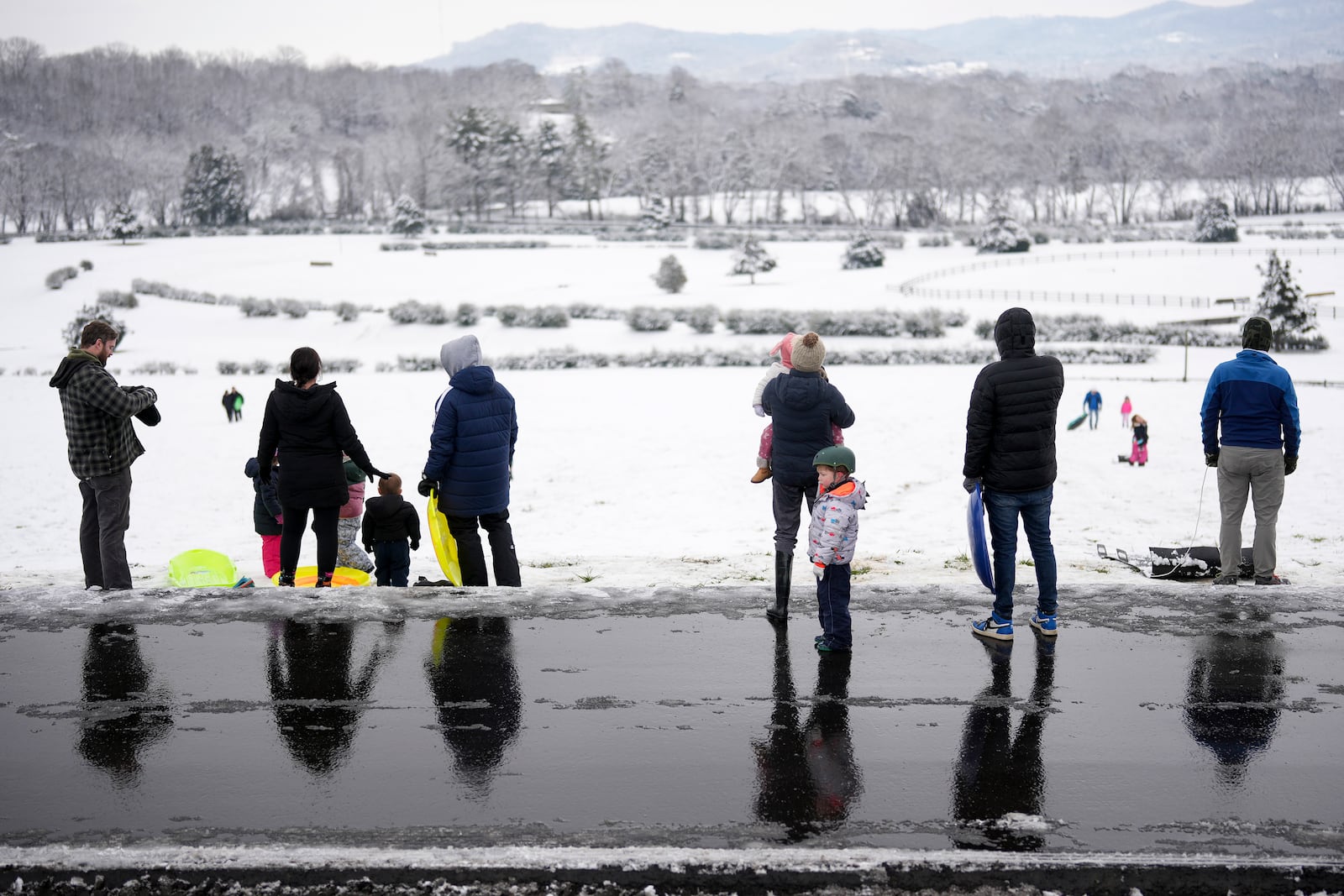 People wait their turn to sled down a hill Saturday, Jan. 11, 2025, in Nashville, Tenn. (AP Photo/George Walker IV)