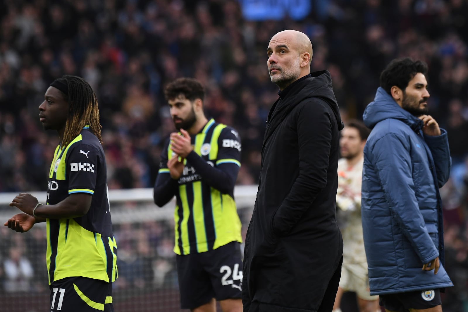 Manchester City's head coach Pep Guardiola, center, and players leave the field at the end of the English Premier League soccer match between Aston Villa and Manchester City, at Villa Park in Birmingham, England, Saturday, Dec. 21, 2024. (AP Photo/Rui Vieira)