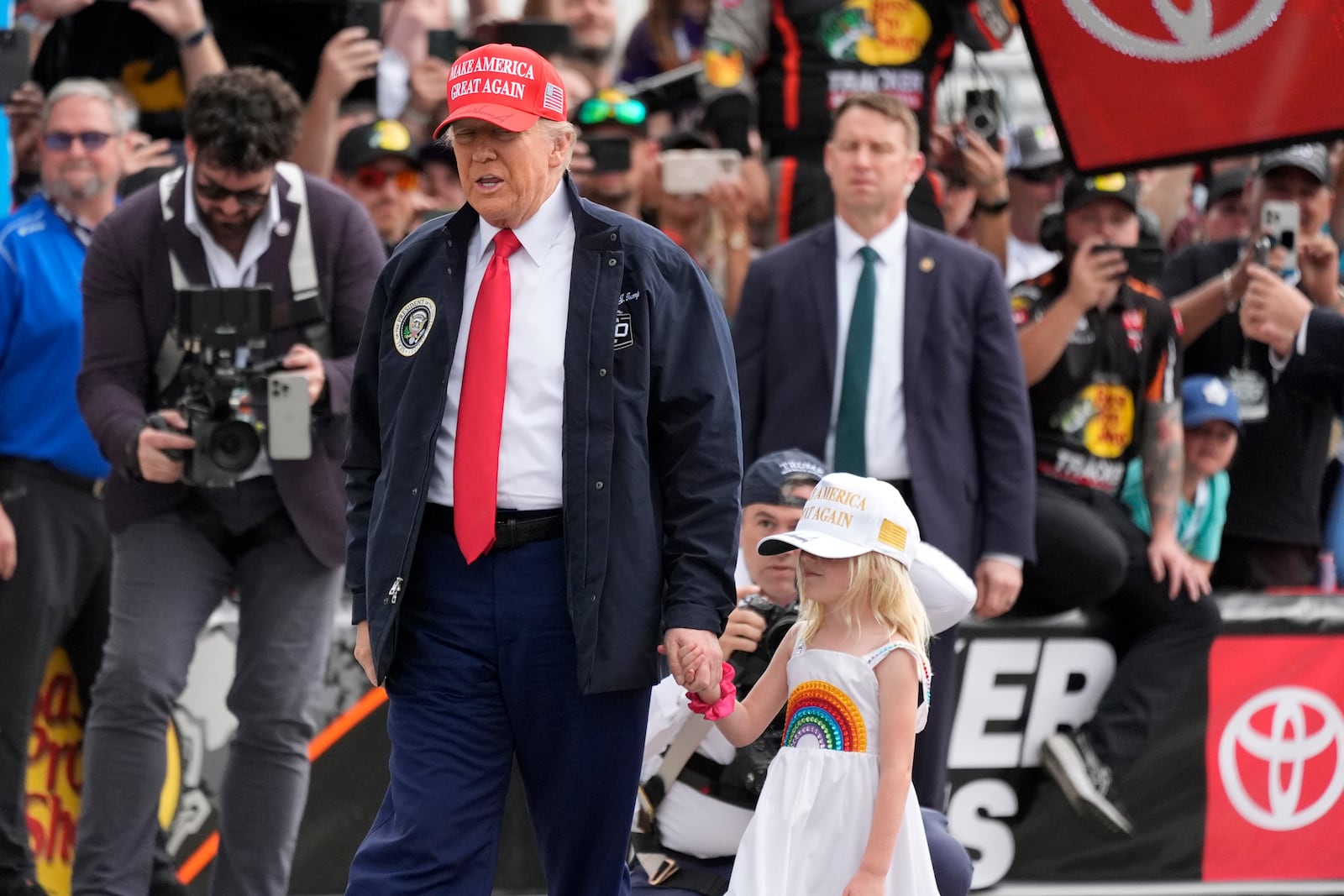 President Donald Trump, left, with his graddaughter Carolina, attends the NASCAR Daytona 500 auto race at Daytona International Speedway, Sunday, Feb. 16, 2025, in Daytona Beach, Fla. (AP Photo/John Raoux)