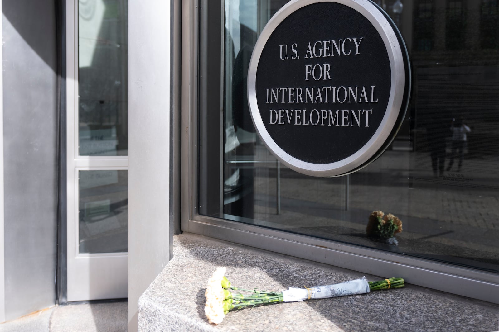 A bouquet of white flowers placed outside the headquarters of the United States Agency for International Development, or USAID, is pictured, Friday, Feb. 7, 2025, in Washington. (AP Photo/Manuel Balce Ceneta)