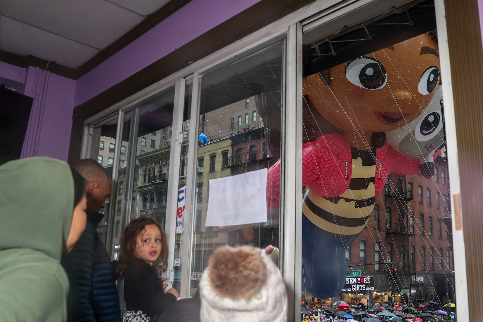 Quenton Lindstrom and his friends and family watch the Macy's Thanksgiving Day parade from above while inside Spirit Lab Yoga, Thursday, Nov. 28, 2024, in New York. (AP Photo/Heather Khalifa)