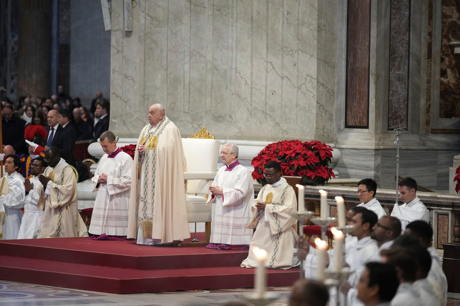 Pope Francis is flanked by Vatican Head Master of Ceremonies, Bishop Diego Giovanni Ravelli, right, and Master of Ceremonies, Bishop Krysztof Marcjanowicz as he presides over a mass in St. Peter's Basilica at The Vatican on New Year's Day, Wednesday, Jan. 1, 2025. (AP Photo/Andrew Medichini)