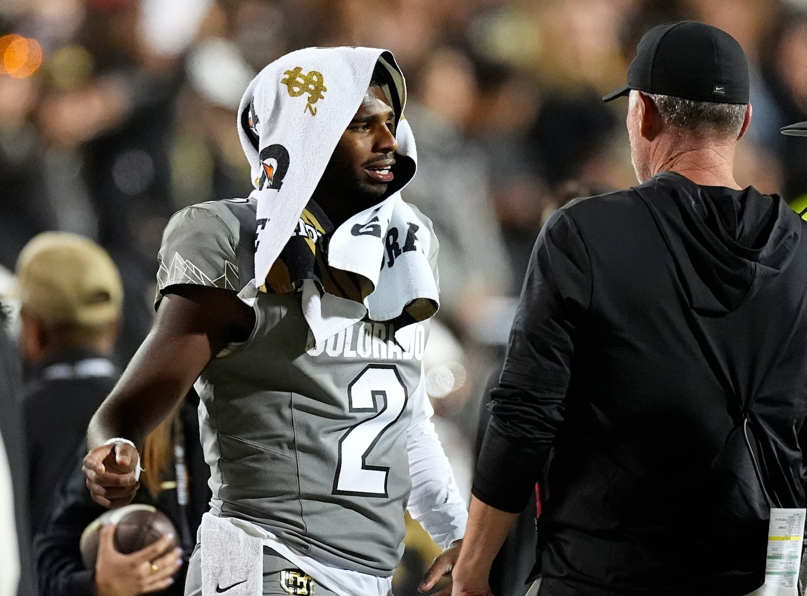 Colorado quarterback Shedeur Sanders, left, confers with offensive coordinator Pat Shurmur in the second half of an NCAA college football game against Cincinnati Saturday, Oct. 26, 2024, in Boulder, Colo. (AP Photo/David Zalubowski)