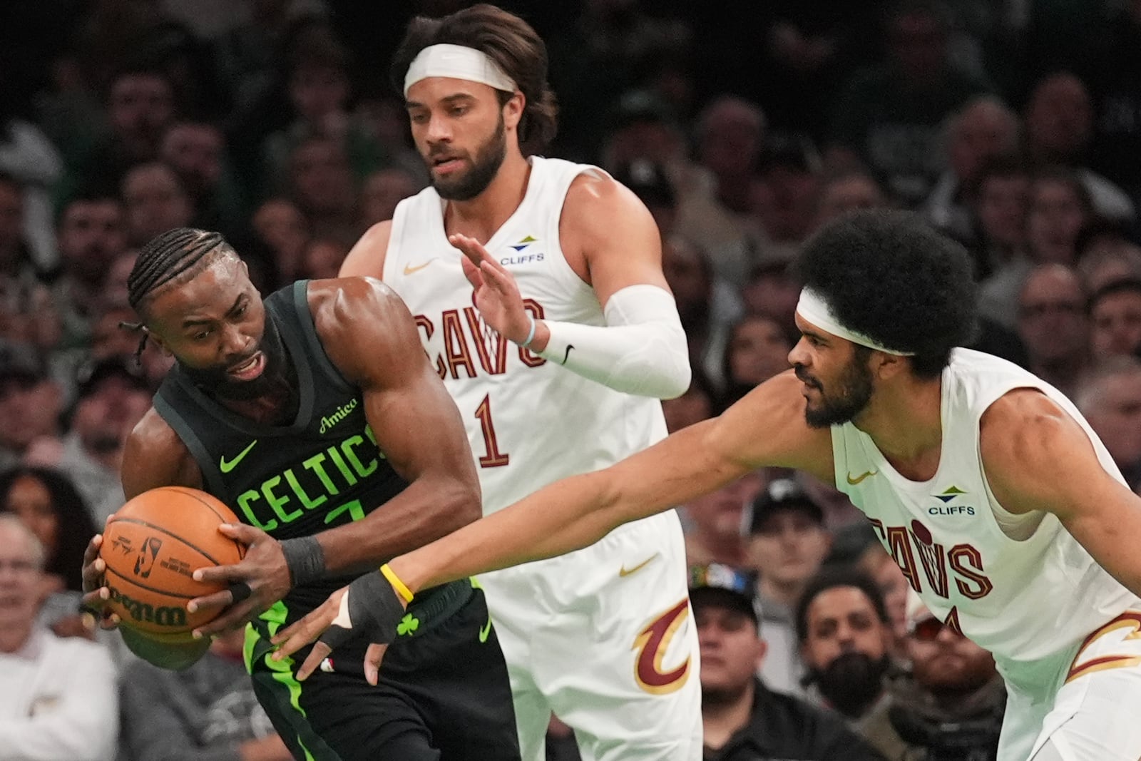 Boston Celtics guard Jaylen Brown, left, is pressured by Cleveland Cavaliers center Jarrett Allen, right, and Cleveland Cavaliers guard Max Strus (1) during the first half of an NBA basketball game, Friday, Feb. 28, 2025, in Boston. (AP Photo/Charles Krupa)