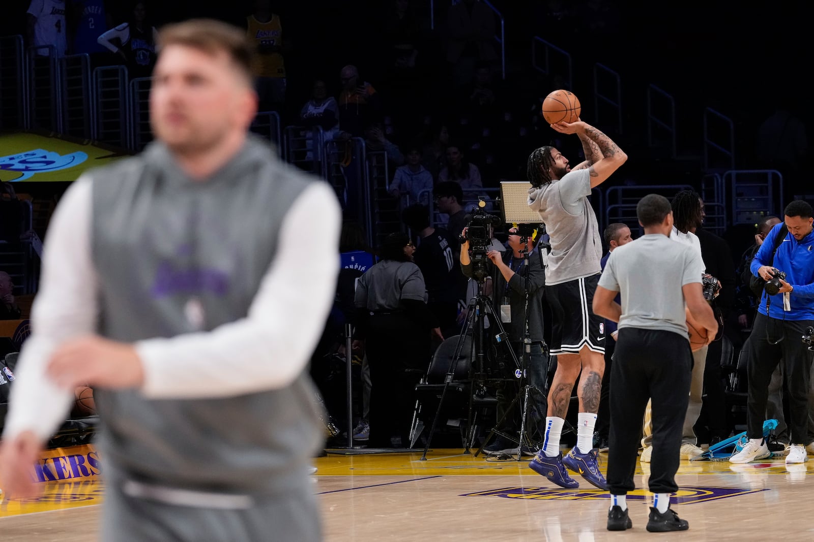 Dallas Mavericks forward Anthony Davis, fourth from right, and Los Angeles Lakers guard Luka Doncic, foreground, warm ups before an NBA basketball game Tuesday, Feb. 25, 2025, in Los Angeles. (AP Photo/Mark J. Terrill)