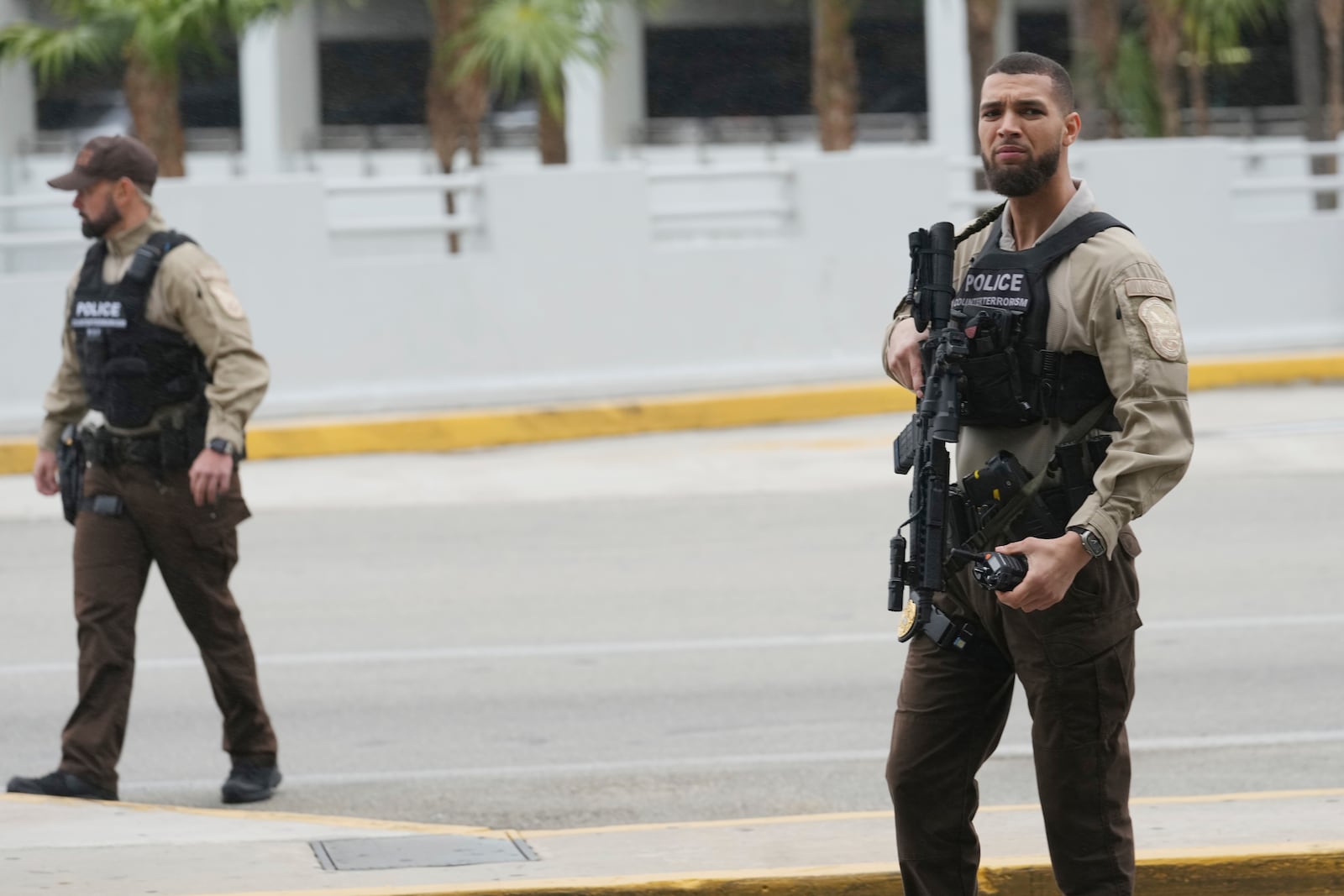 Armed police patrol a gate where Enrique Tarrio departed from at Miami International Airport, Wednesday, Jan. 22, 2025, in Miami. Tarrio was pardoned by President Donald Trump after he was convicted of seditious conspiracy for his role in the January 6 attack on the U.S. Capitol. (AP Photo/Marta Lavandier)