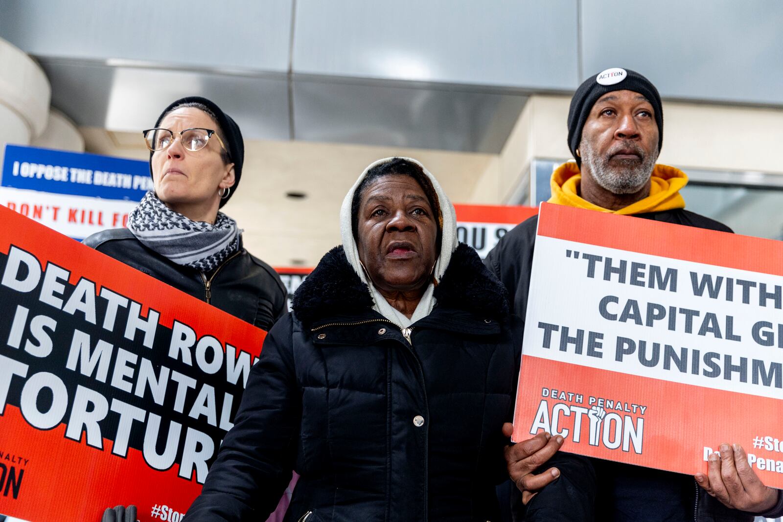 Lizz Schallert, left, and Charles Keith, right, stand in solidarity with Carol Frazier, mother of Demetrius Frazier, as she pleads publicly Tuesday, Jan. 28, 2025, in Lansing, Mich., to Gov. Gretchen Whitmer to bring home her son Demetrius, a Detroit man convicted of rape and a separate murder of a 14-year-old in the early 1990s, who was serving a life sentence when he was charged with another murder in Alabama and is scheduled to be executed there Feb. 6. (Jake May/MLive.com/The Flint Journal via AP)