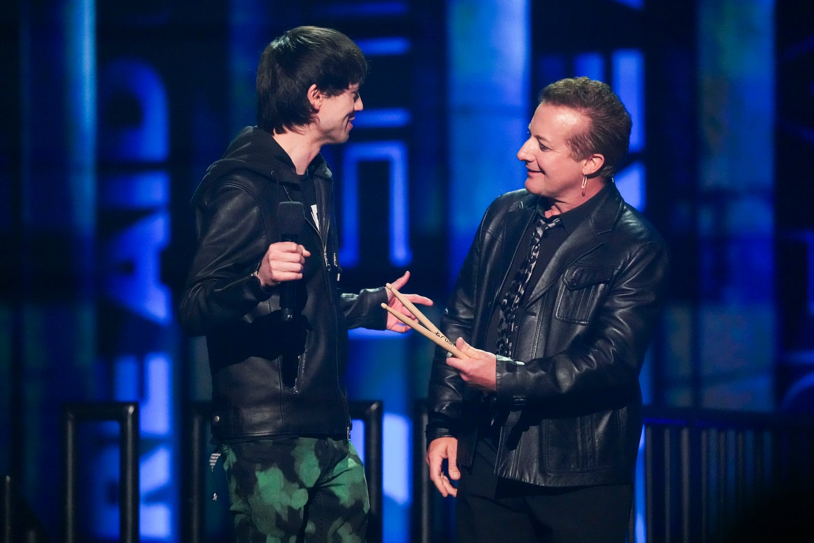 Chad Comey, left, receives a pair of drumsticks from Tre Cool during the FireAid benefit concert on Thursday, Jan. 30, 2025, at Intuit Dome in Inglewood, Calif. (Photo by Jordan Strauss/Invision/AP)