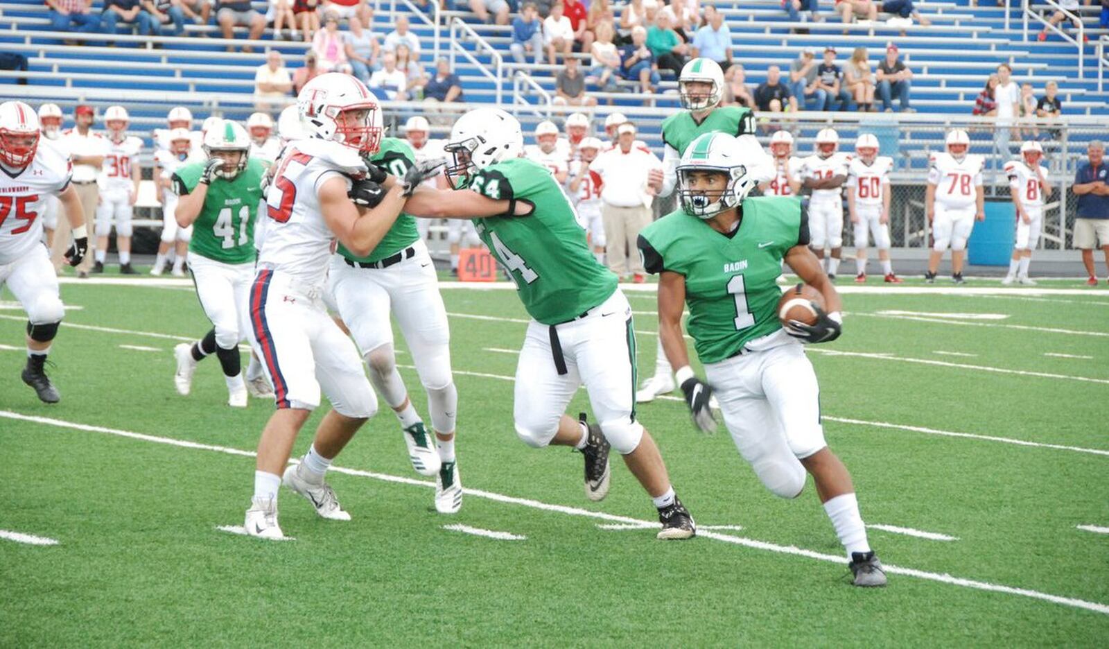 Badin’s Davon Starks (1) gets a block from teammate Andrew Jones on Friday night against Talawanda at Hamilton’s Virgil Schwarm Stadium. Inclement weather forced the game to be completed at Talawanda on Saturday, with Badin winning 38-7. CONTRIBUTED PHOTO BY OLIVER SANDERS