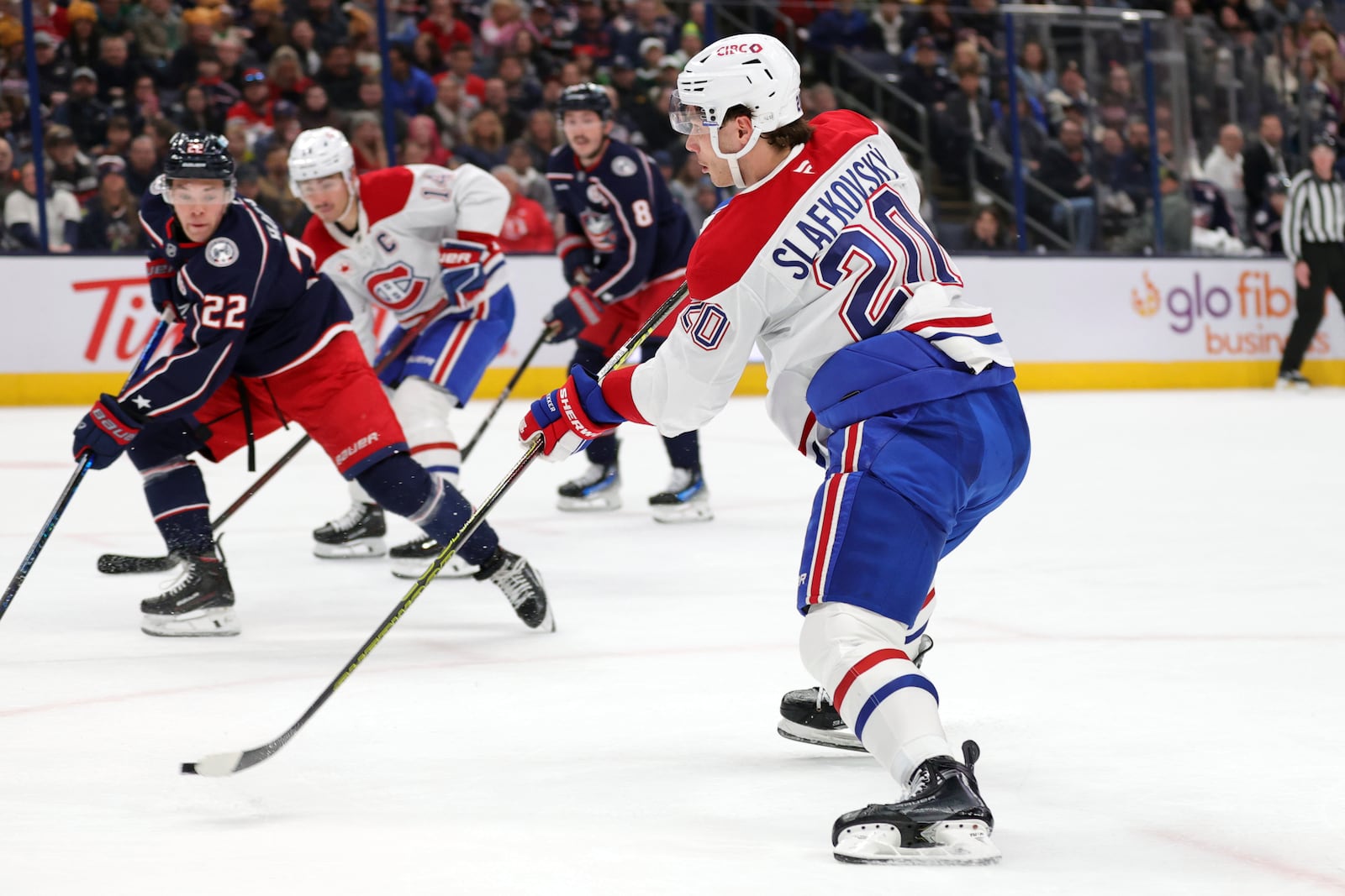 Montreal Canadiens forward Juraj Slafkovsky, right, shoots the puck in front of Columbus Blue Jackets defenseman Jordan Harris during the first period of an NHL hockey game in Columbus, Ohio, Wednesday, Nov. 27, 2024. Slafkovsky scored on the play. (AP Photo/Paul Vernon)