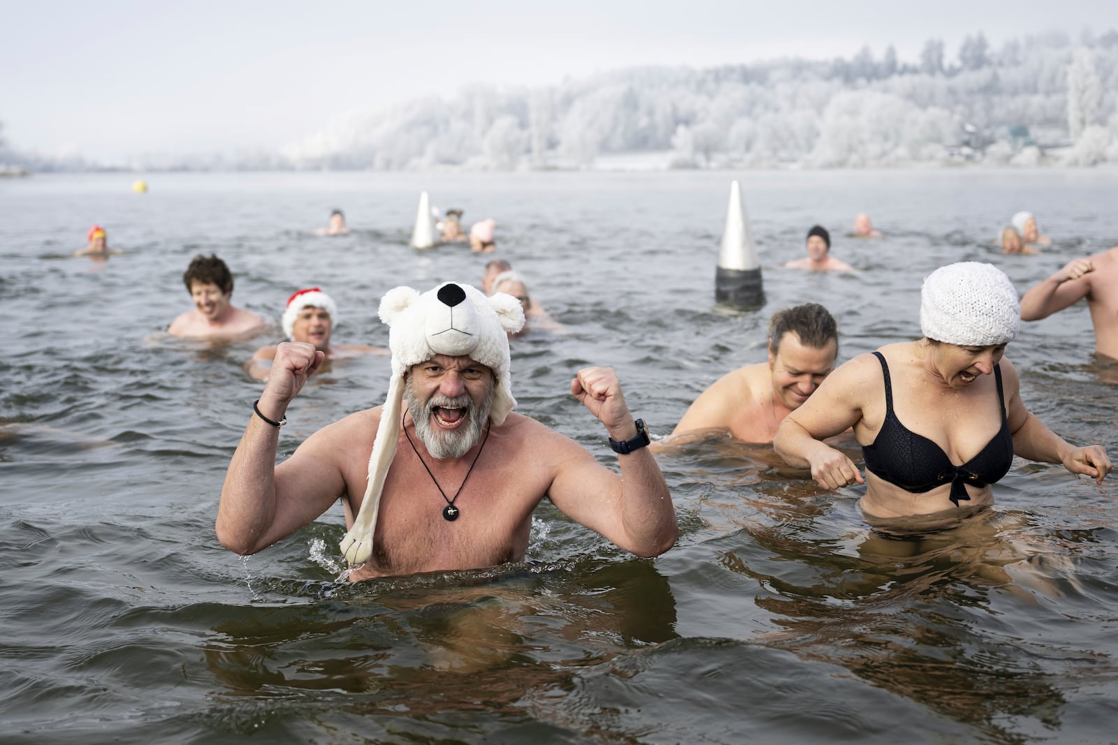 Swimmers attend the traditional New Year's Eve swimming at lake Moossee in Moosseedorf, Switzerland, Tuesday, December 31, 2024. (Anthony Anex/Keystone via AP)