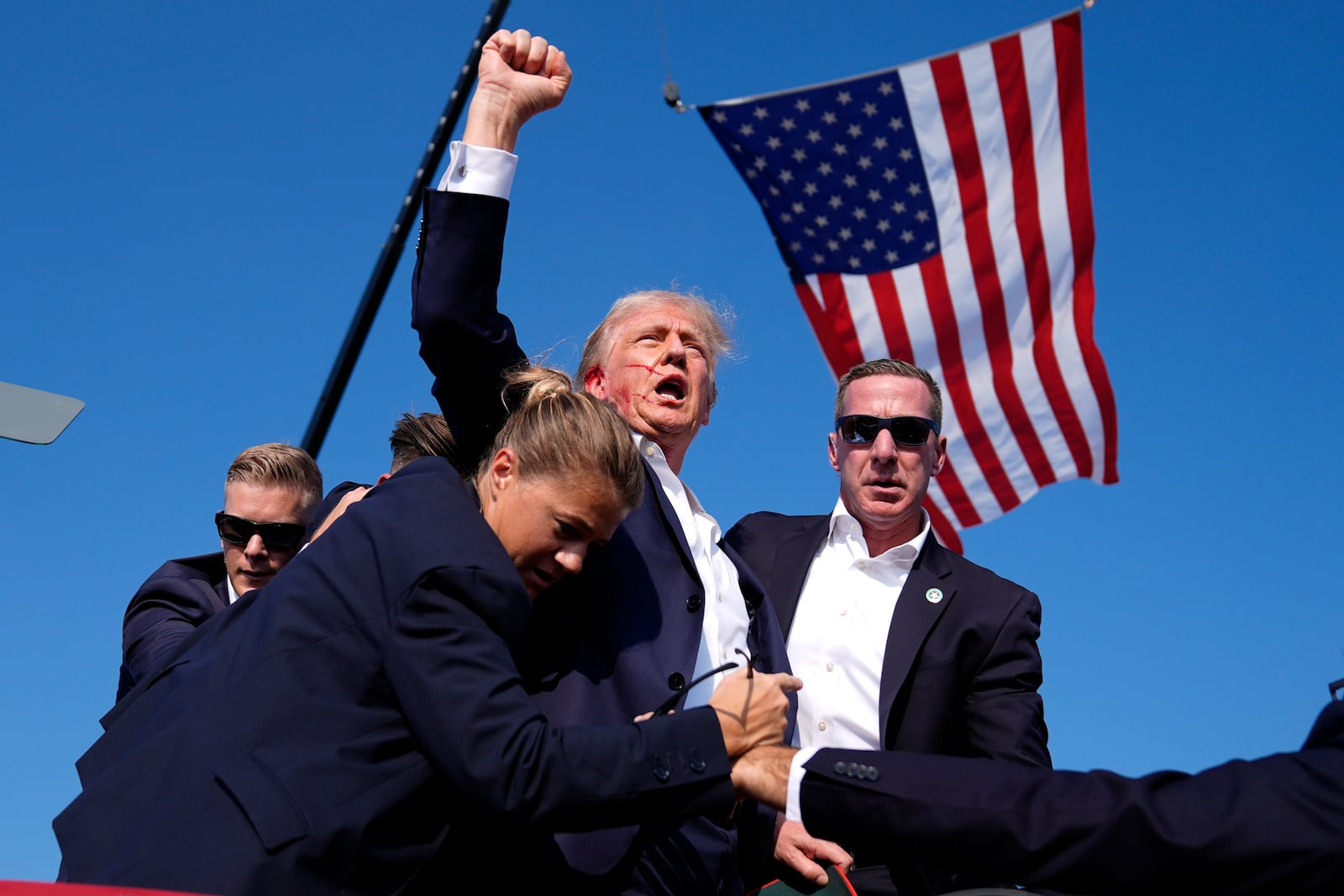 FILE - Republican presidential candidate former President Donald Trump is surrounded by U.S. Secret Service agents after an assassination attempt at a campaign rally in Butler, Pa., July 13, 2024. (AP Photo/Evan Vucci, File)