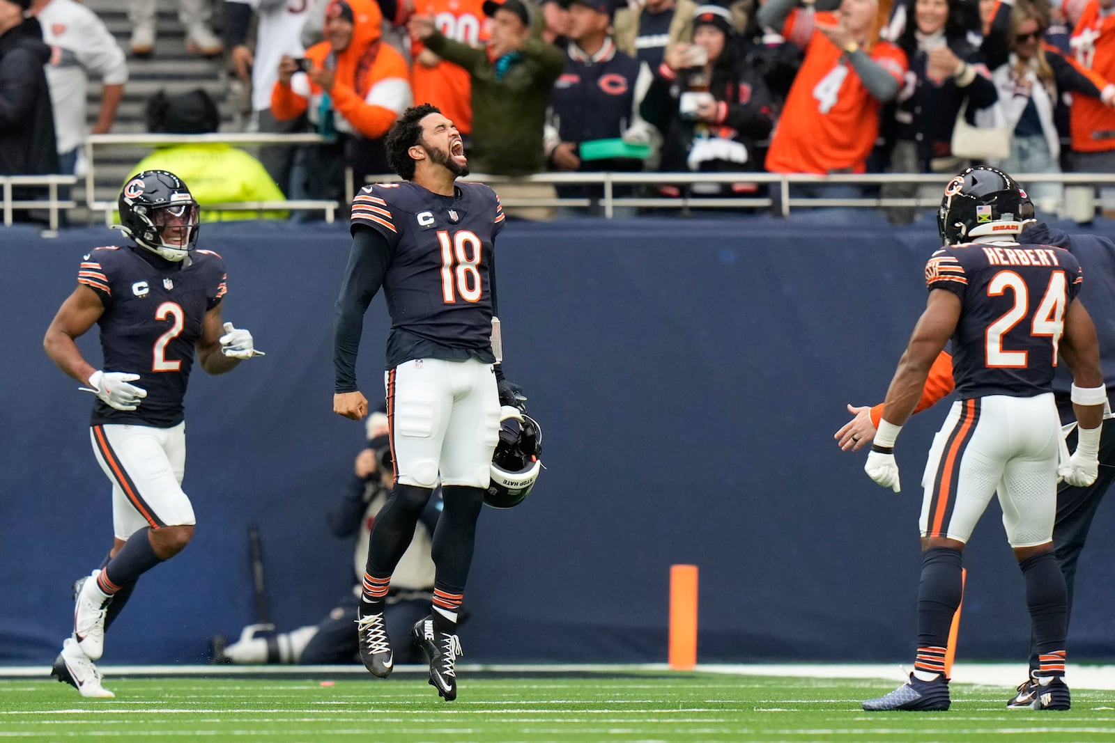 Chicago Bears quarterback Caleb Williams (18) celebrates after Bears wide receiver Keenan Allen (13) scored his side's third touchdown during the third quarter of an NFL football game at the Tottenham Hotspur stadium between the Jacksonville Jaguars and Chicago Bears in London, Sunday, Oct. 13, 2024. (AP Photo/Steve Luciano)