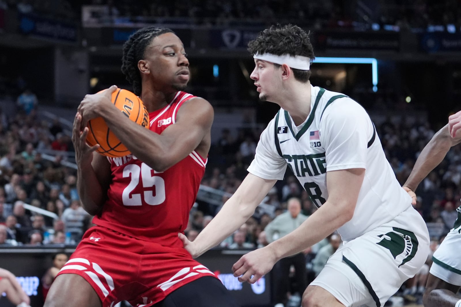 Wisconsin guard John Blackwell (25) pulls down a rebound on Michigan State forward Frankie Fidler (8) during the first half of an NCAA college basketball game in the semifinals of the Big Ten Conference tournament in Indianapolis, Saturday, March 15, 2025. (AP Photo/Michael Conroy)