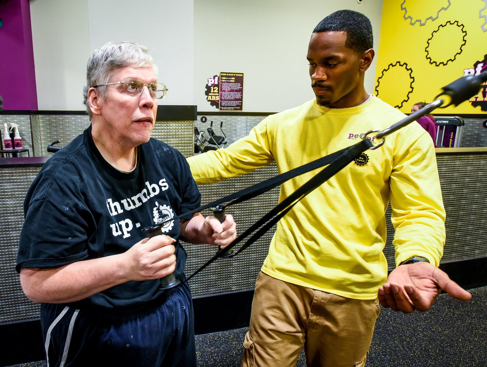 Brian Hall completes a circuit routine under the guidance of Planet Fitness instructor Deandre Allen as part of the Ability To Thrive Program in Middletown. NICK GRAHAM/STAFF