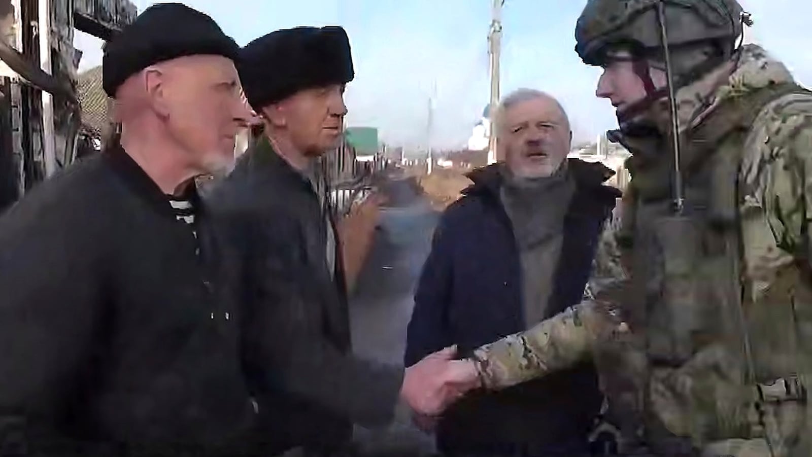 In this photo taken from video distributed by Russian Defense Ministry Press Service on Friday, March 14, 2025, a Russian soldier greets local citizens of Sudzha, the biggest town in the Kursk region of Russia after it was taken over by Russian troops. (Russian Defense Ministry Press Service via AP)