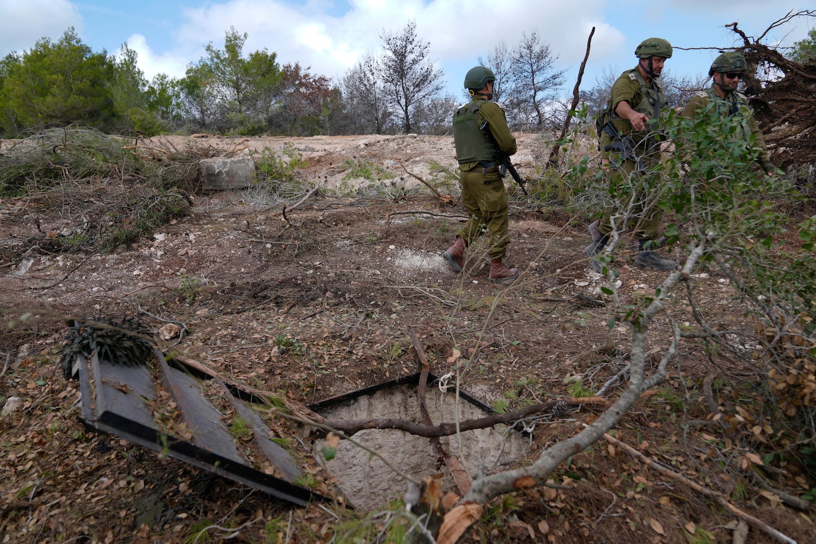 Israeli soldiers display what they say is an entrance to a Hezbollah tunnel found during their ground operation in southern Lebanon, near the border with Israel, Sunday, Oct. 13, 2024. (AP Photo/Sam McNeil)