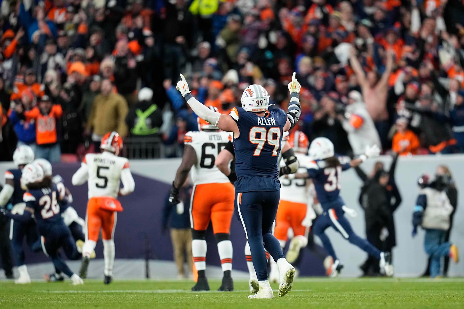 Denver Broncos defensive end Zach Allen (99) celebrates teammate cornerback Ja'Quan McMillian's 46-yard interception return for a touchdown during the second half of an NFL football game against the Cleveland Browns, Monday, Dec. 2, 2024, in Denver. (AP Photo/Jack Dempsey)