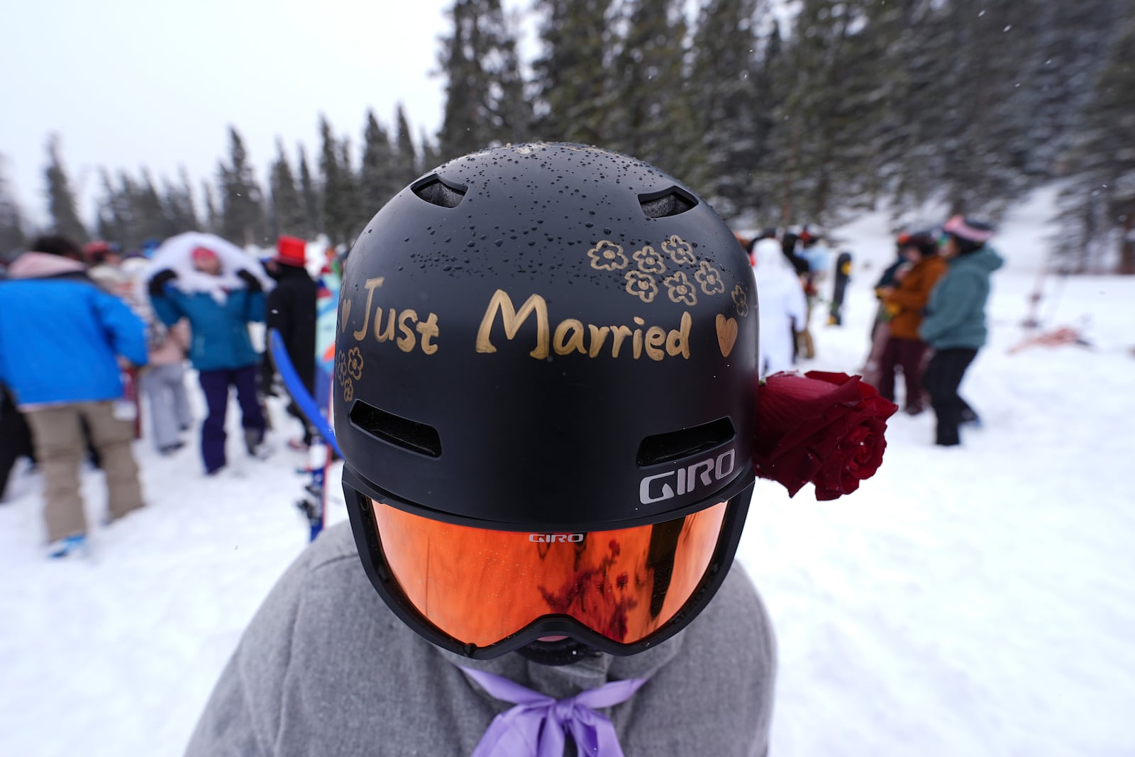 Xiaolin Chen wears a message on her ski helmet after she married Carter Paquette of Denver during the 35th annual Marry Me & Ski for Free Valentine's Day mountaintop matrimony ceremony Friday, Feb. 14, 2025, at Loveland Ski Area, Colo. (AP Photo/David Zalubowski)