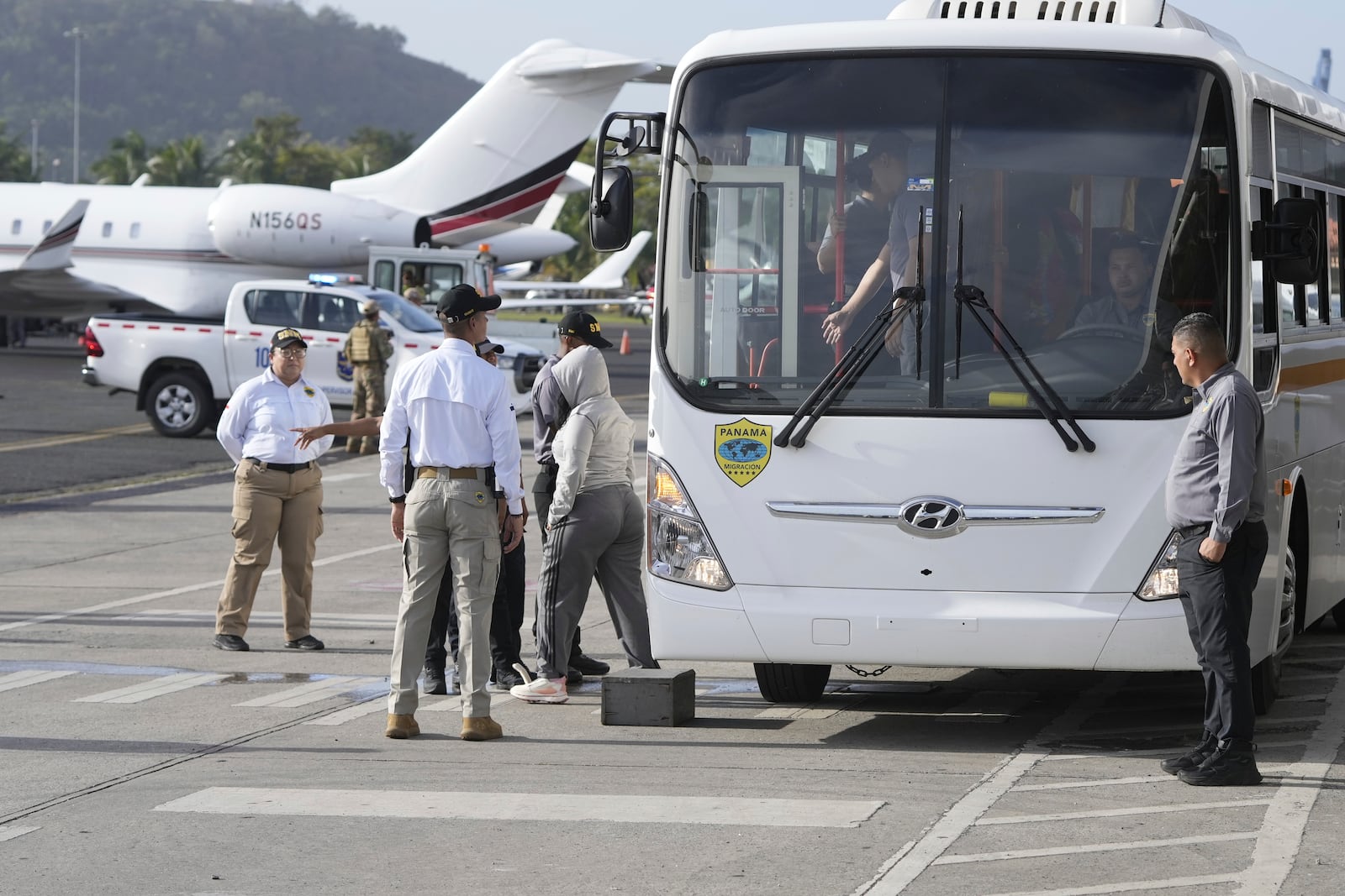 People arrive to board a repatriation flight bound for Colombia at Albrook Airport in Panama City, Monday, Feb. 3, 2025. (AP Photo/Mark Schiefelbein, Pool)