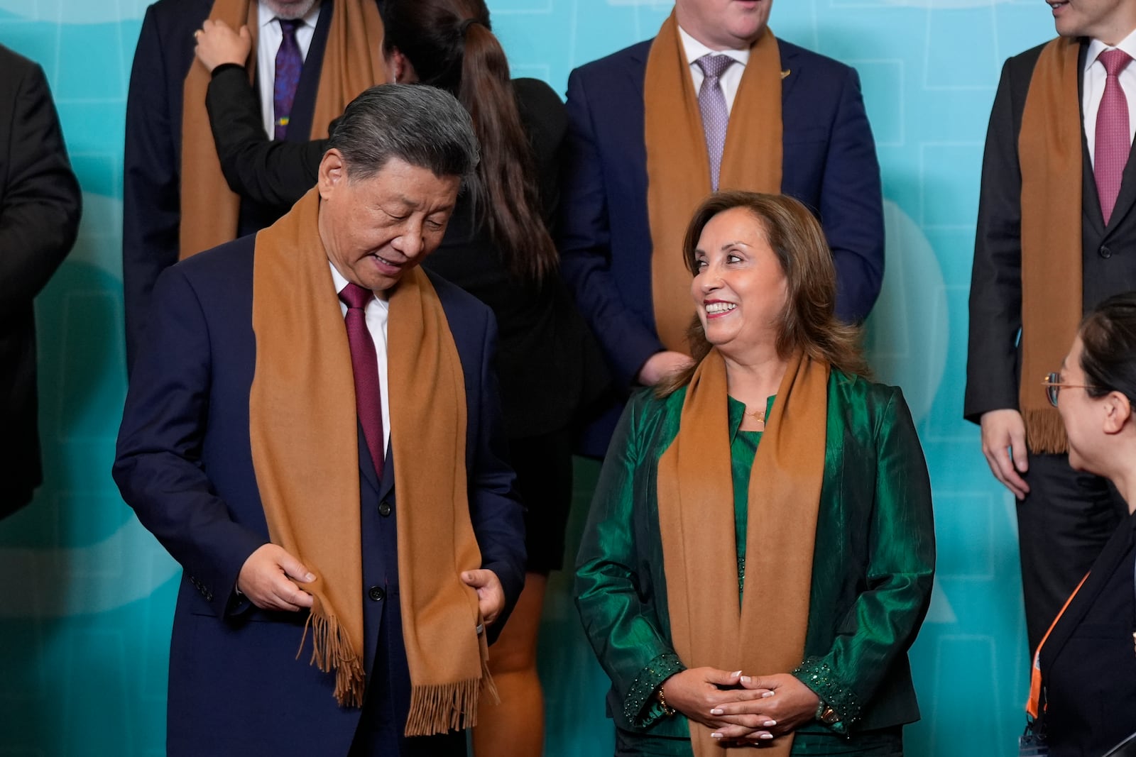 China's President Xi Jinping, left, speaks with Peru's President Dina Boluarte, right, as they and other APEC leaders gather for a family photograph at the APEC Summit in Lima, Peru on Saturday, Nov. 16, 2024. (AP Photo/Manuel Balce Ceneta)