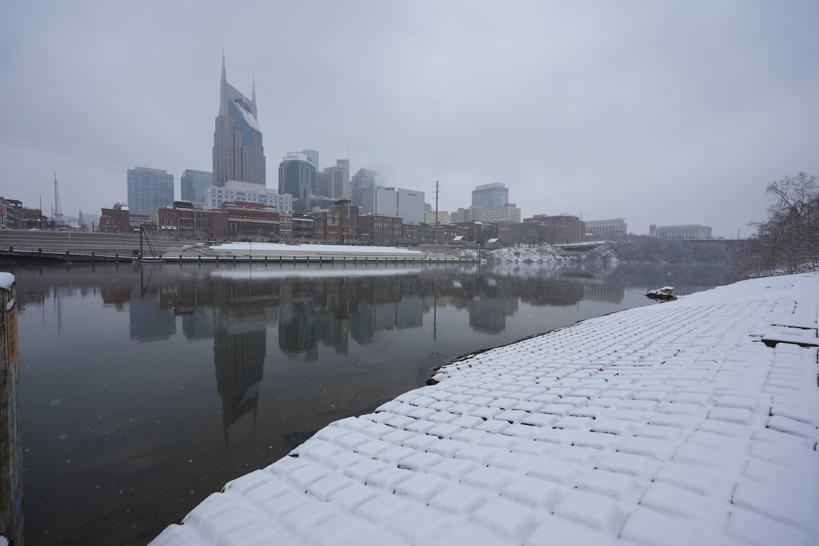 Downtown skyline is reflected on Cumberland River, as the snow falls Friday, Jan 10, 2025, in Nashville, Tenn. (AP Photo/George Walker IV)