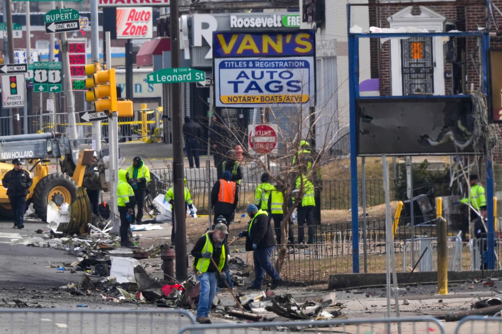 Workers collect debris in the aftermath of a fatal small plane crashed in Philadelphia, Monday, Feb. 3, 2025. (AP Photo/Matt Rourke)