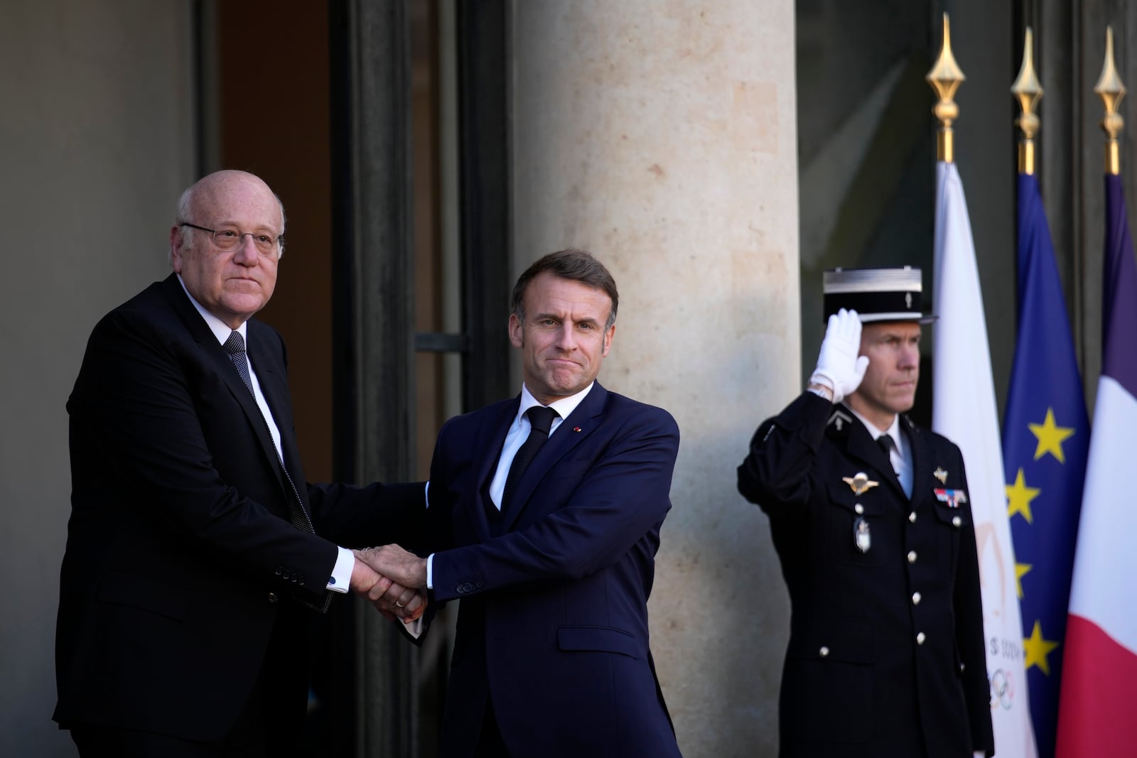 French President Emmanuel Macron welcomes Lebanese caretaker Prime Minister Najib Mikati, left, Wednesday, Oct. 23, 2024 at the Elysee Palace in Paris. (AP Photo/Louise Delmotte)