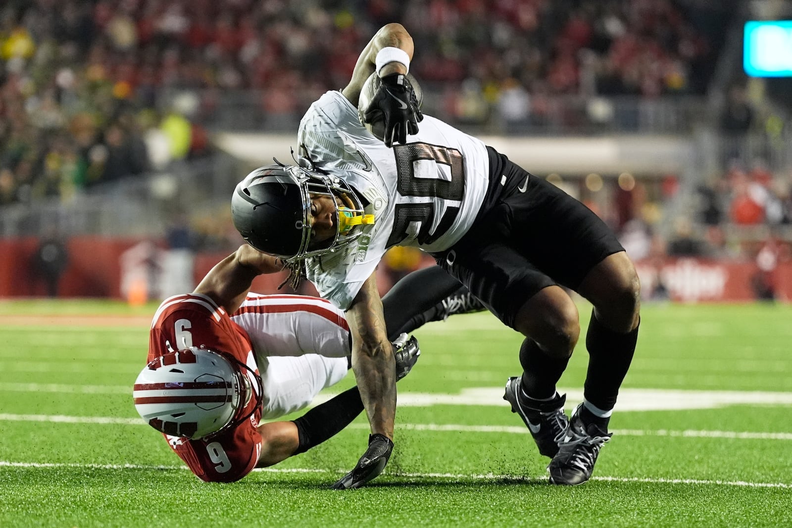 Wisconsin's Austin Brown (9) stops Oregon's Jordan James (20) during the second half of an NCAA college football game Saturday, Nov. 16, 2024, in Madison, Wis. Oregon won 16-13. (AP Photo/Morry Gash)