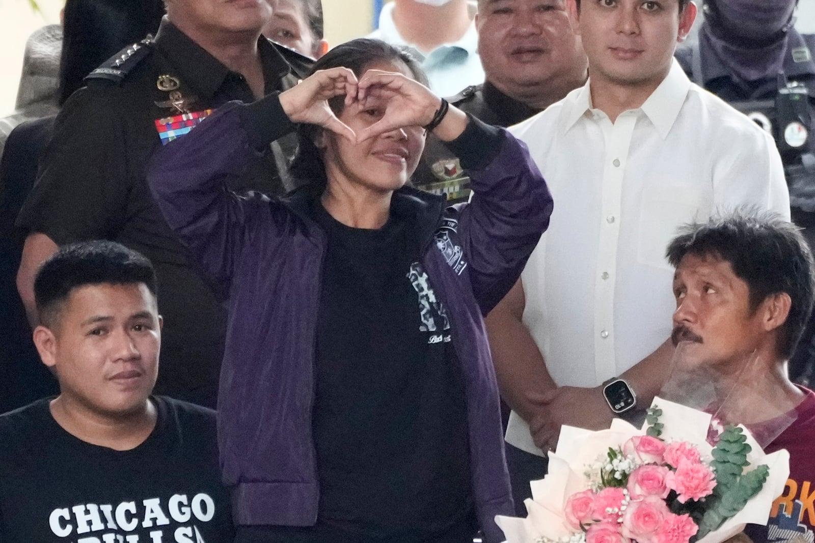 Mary Jane Veloso, center, a Filipino woman who spent almost 15 years in an Indonesian prison for drug trafficking and was nearly executed by firing squad in 2015, shows a heart sign as she is reunited with her sons and husband as she arrives at the Correctional Institution for Women in Mandaluyong, Philippines Wednesday, Dec. 18, 2024. (AP Photo/Aaron Favila)