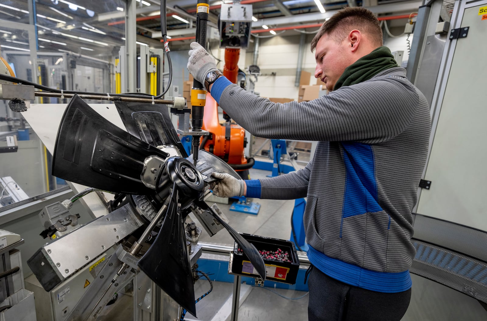 A man works on fans at an EBM-Papst plant in Hollenbach, Germany, Tuesday, Feb. 4, 2025. (AP Photo/Michael Probst)