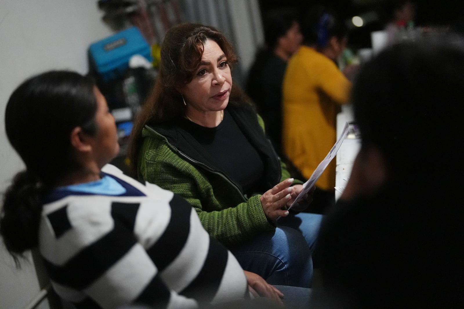 Nora Sandigo, center, who runs a non-profit dedicated to supporting immigrant families, speaks with women worried about the possibility of being deported, to educate them about their legal rights and options to protect their families, Friday, Jan. 17, 2025, in Florida City, Fla. (AP Photo/Rebecca Blackwell)