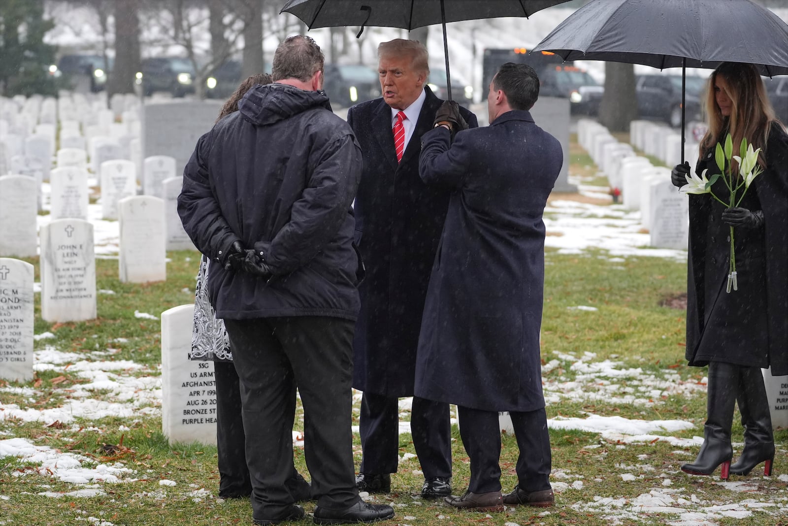 President-elect Donald Trump and Melina Trump talks with family members in Section 60 at Arlington National Cemetery, Sunday, Jan. 19, 2025, in Arlington, Va. (AP Photo/Evan Vucci)