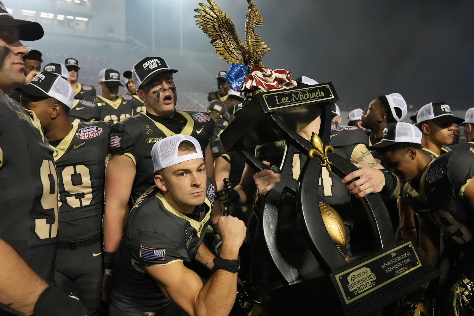 Army players hoist the winner's trophy following their win over Louisiana Tech during a NCAA college football game, Saturday, Dec. 28, 2024, in Shreveport, La. (AP Photo/Rogelio V. Solis)