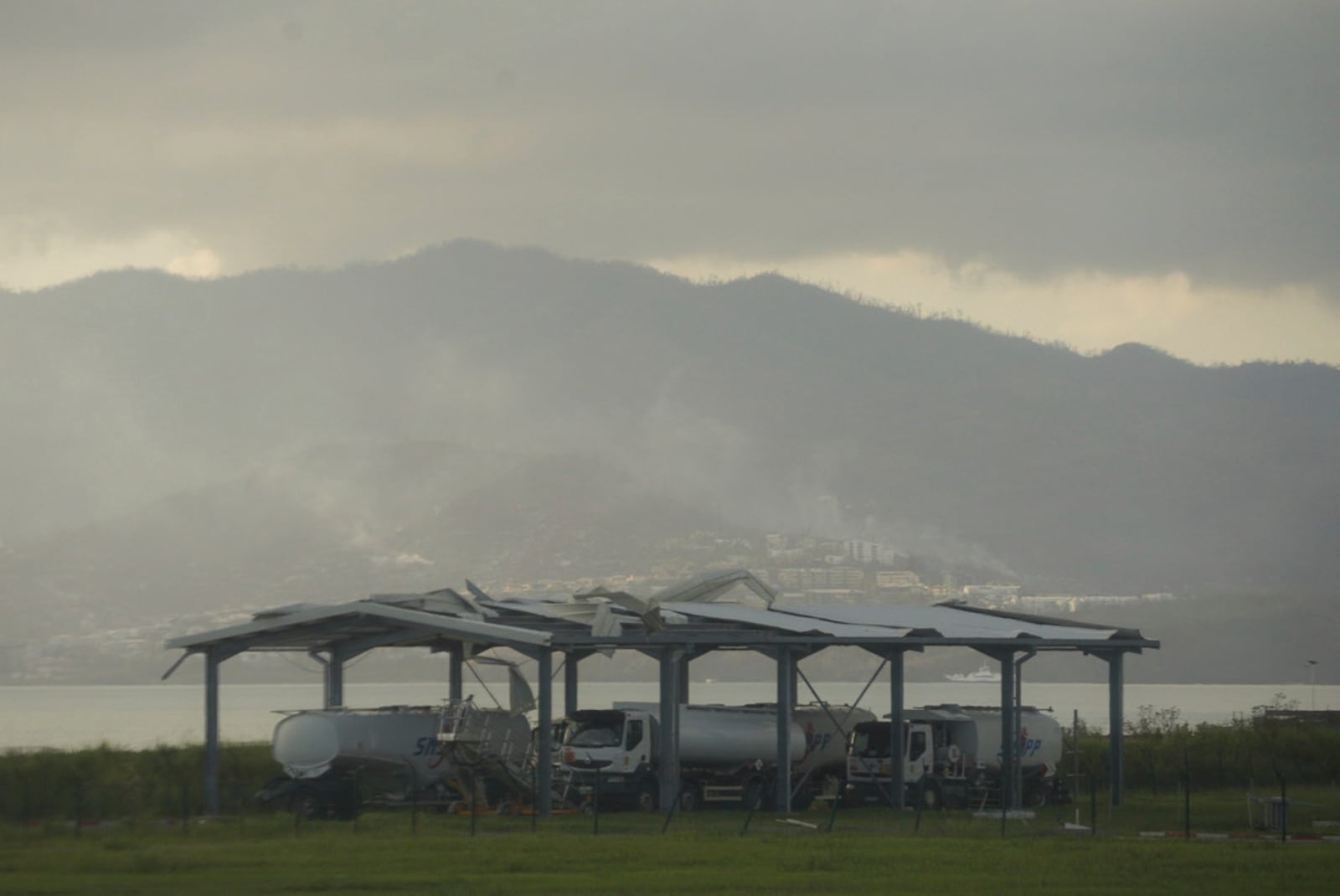 Smoke rises from destroyed dwellings Wednesday, Dec. 18, 2024 in the French Indian Ocean island of Mayotte. (AP Photo/Adrienne Surprenant)