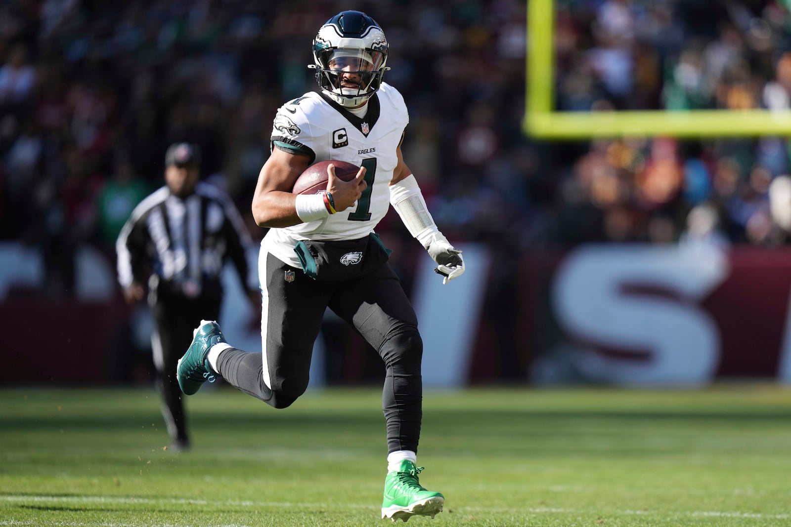 Philadelphia Eagles quarterback Jalen Hurts (1) running with the ball during the first half of an NFL football game against the Washington Commanders, Sunday, Dec. 22, 2024, in Landover, Md. (AP Photo/Stephanie Scarbrough)